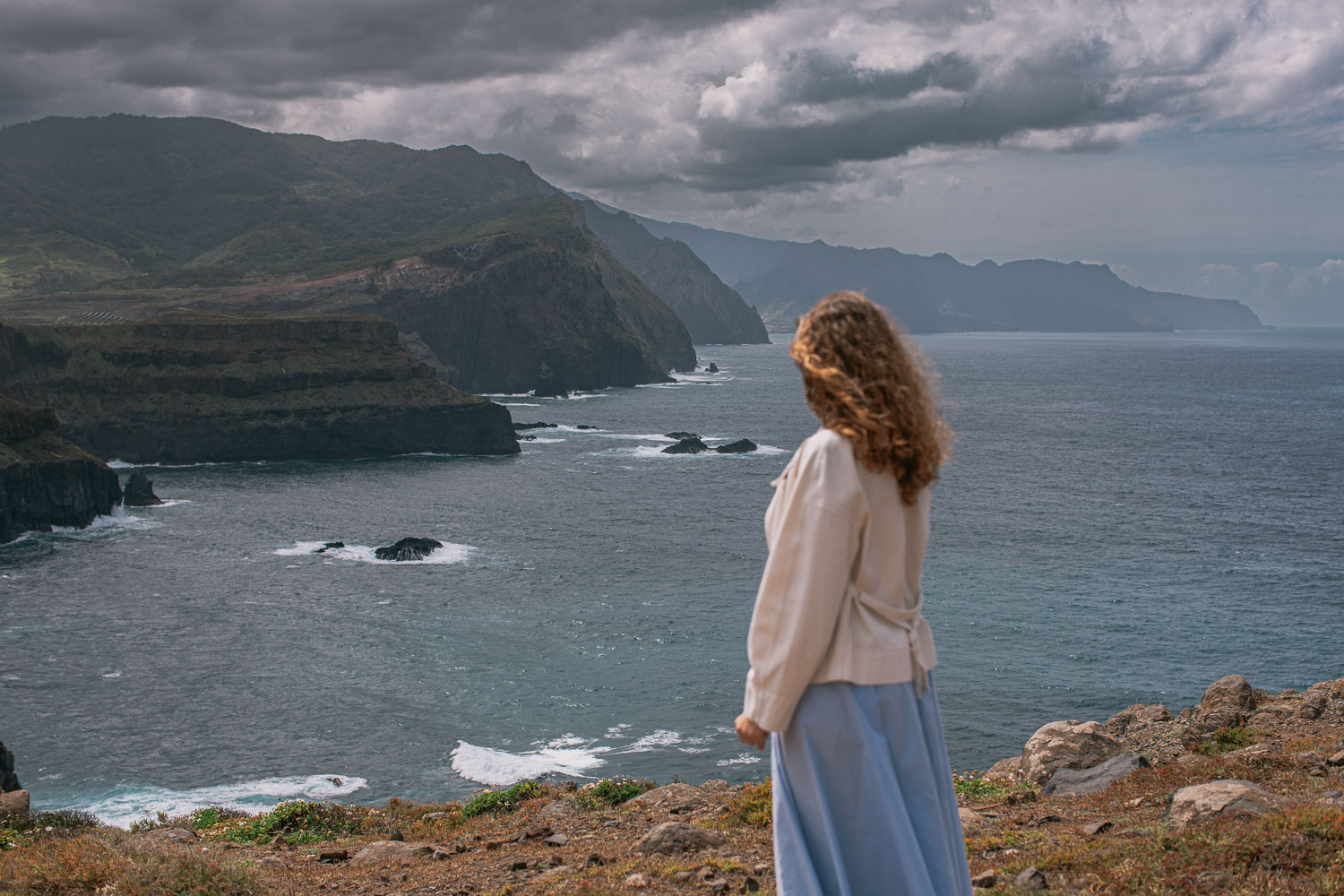 Atlantic cliffs of Ponta de São Lourenço peninsula, woman at viewpoint looking east, Madeira