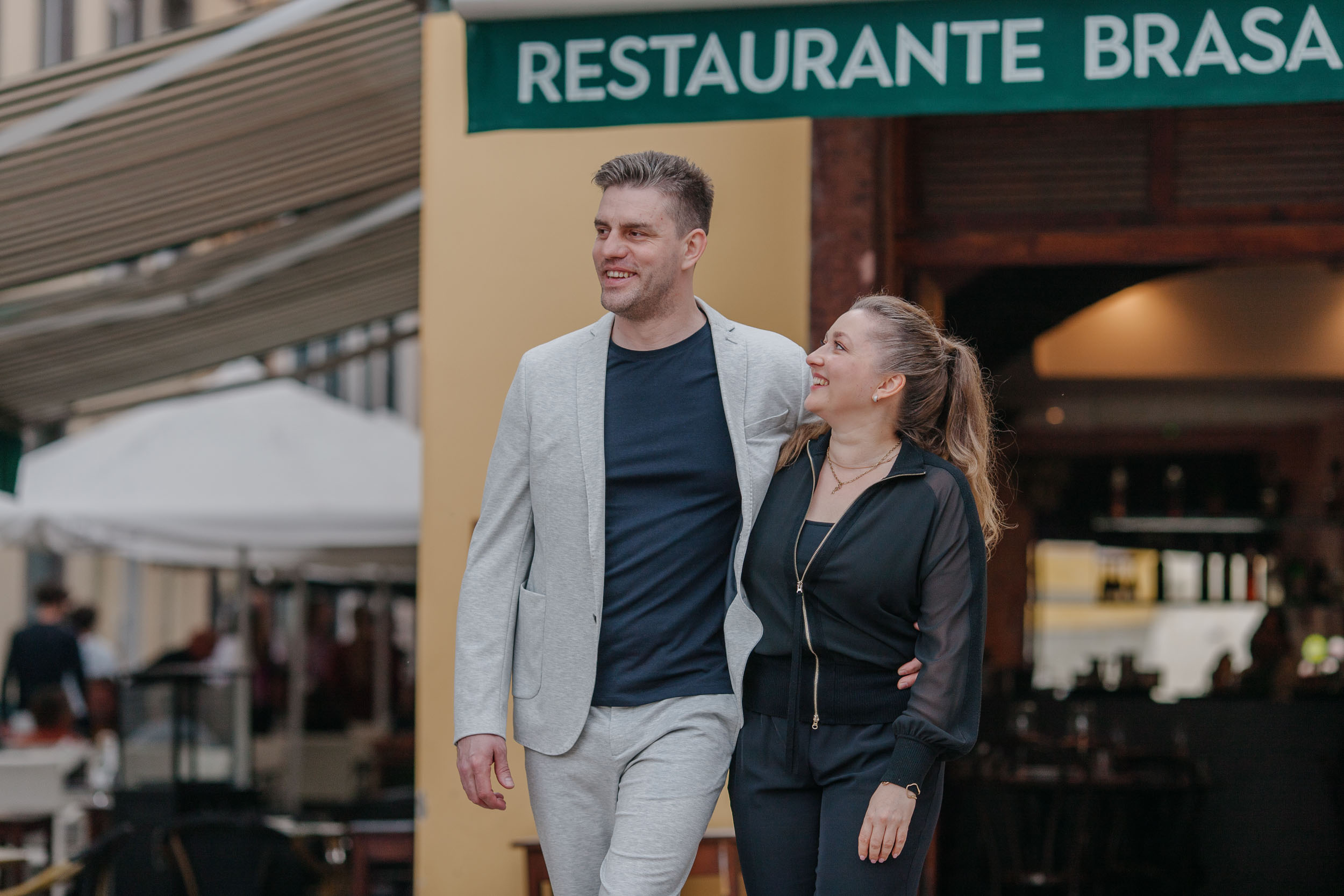Couple smiling at camera outside Restaurante Brasa, colorful street, Old Town Funchal, Madeira