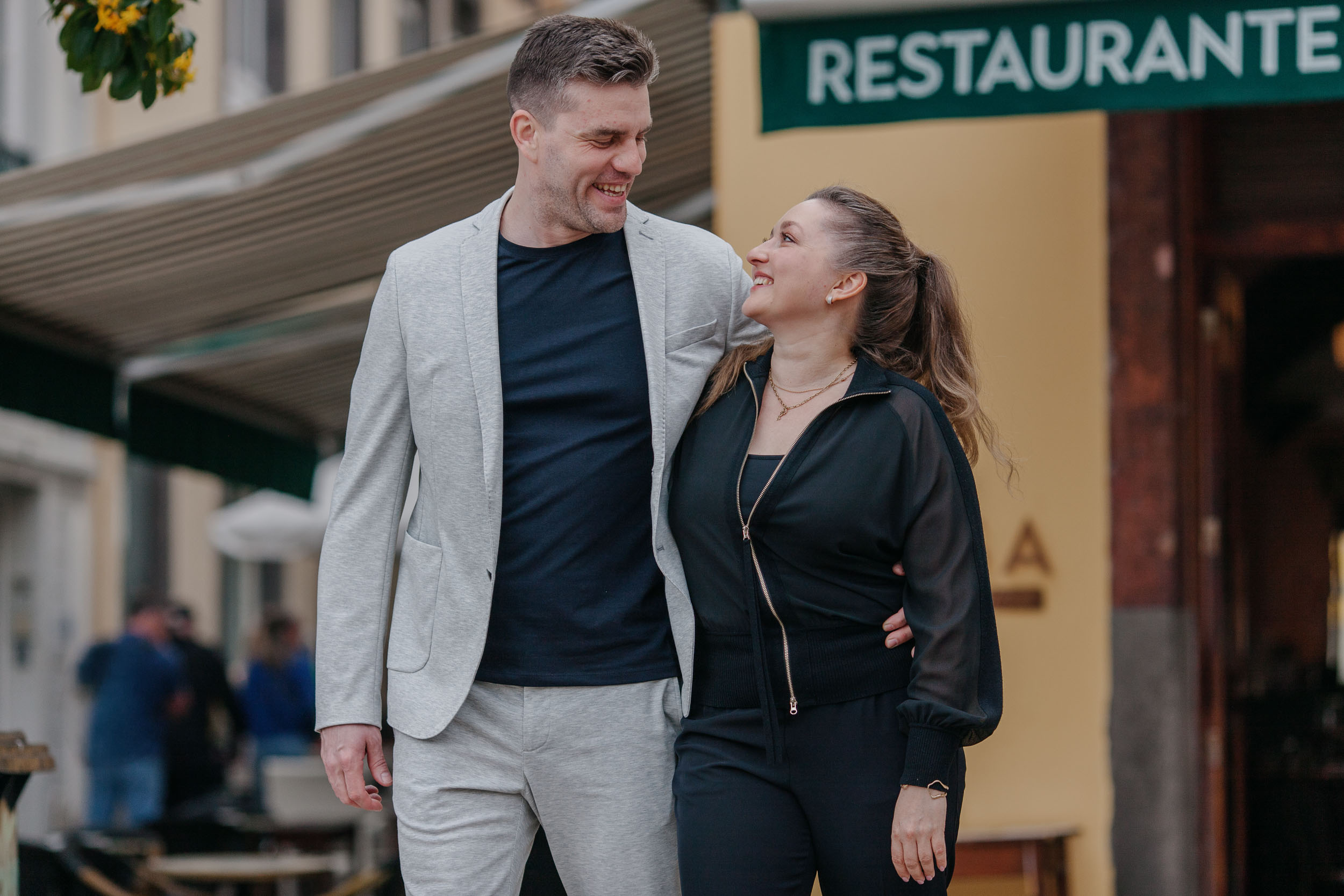 Couple looking at each other warmly outside a restaurant in Funchal Old Town, cobblestone street, Madeira