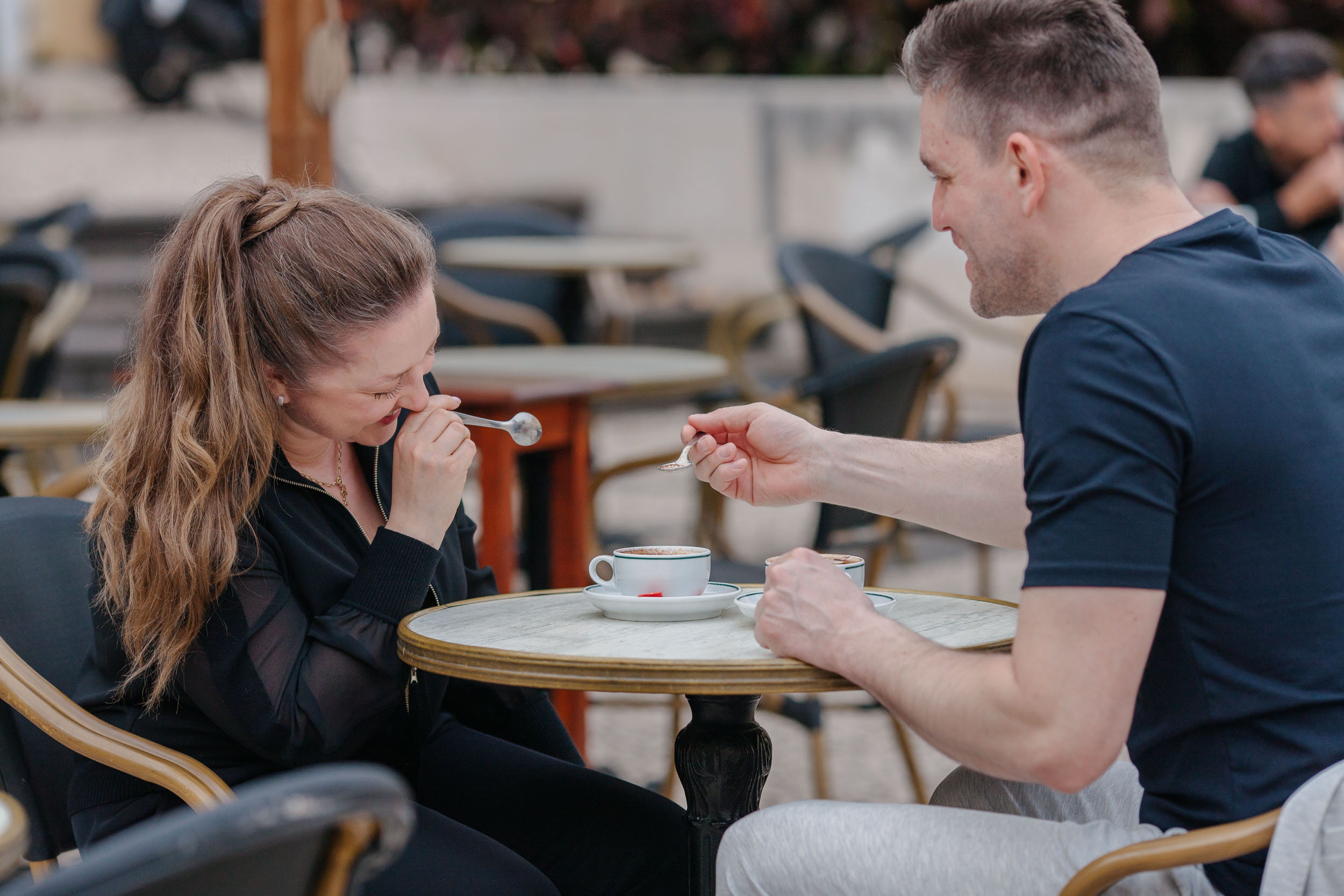 Couple leaning toward each other at cafe table, candid close moment, Funchal, Madeira