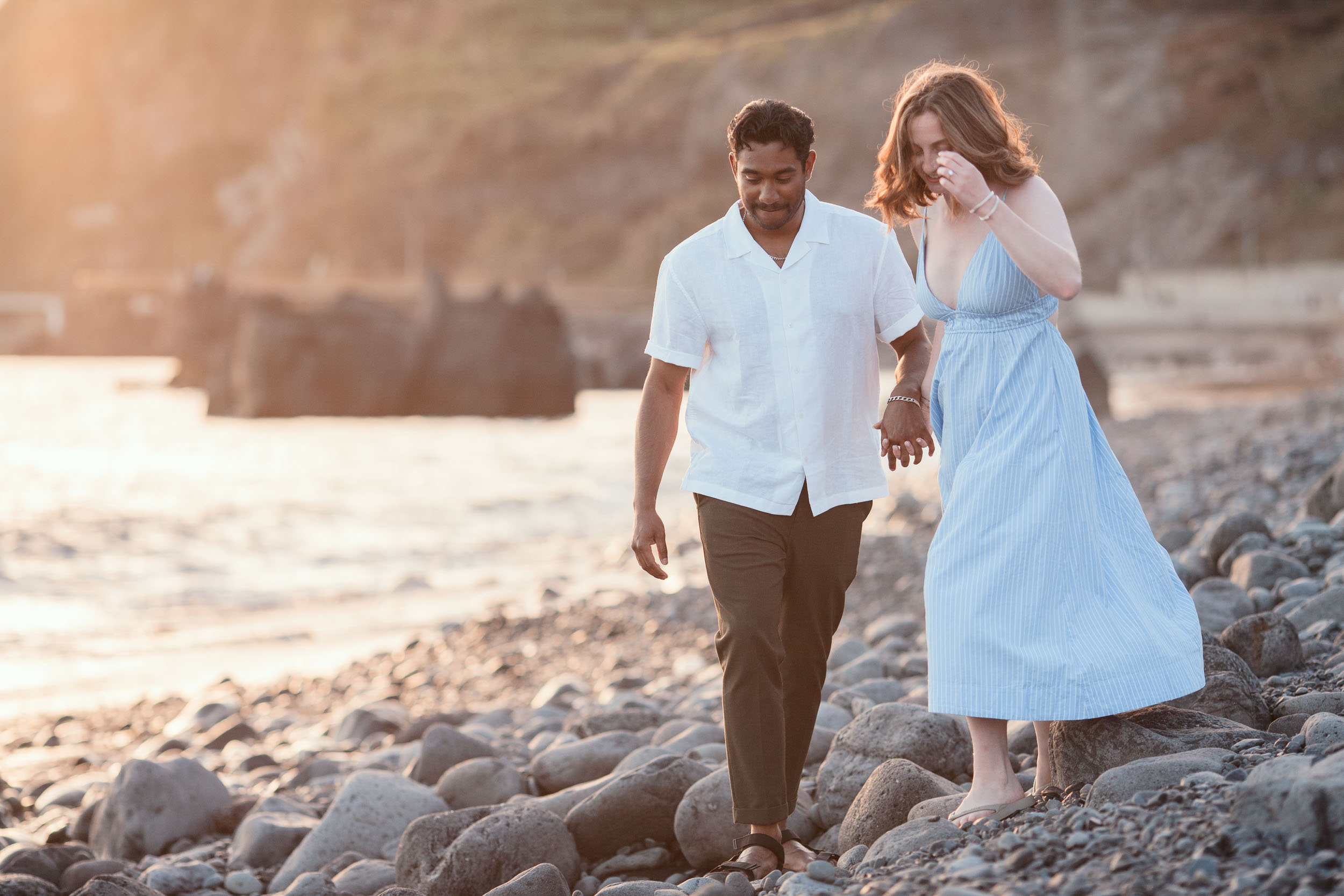 Couple wading in ocean shallows at dusk, Praia Formosa, Madeira