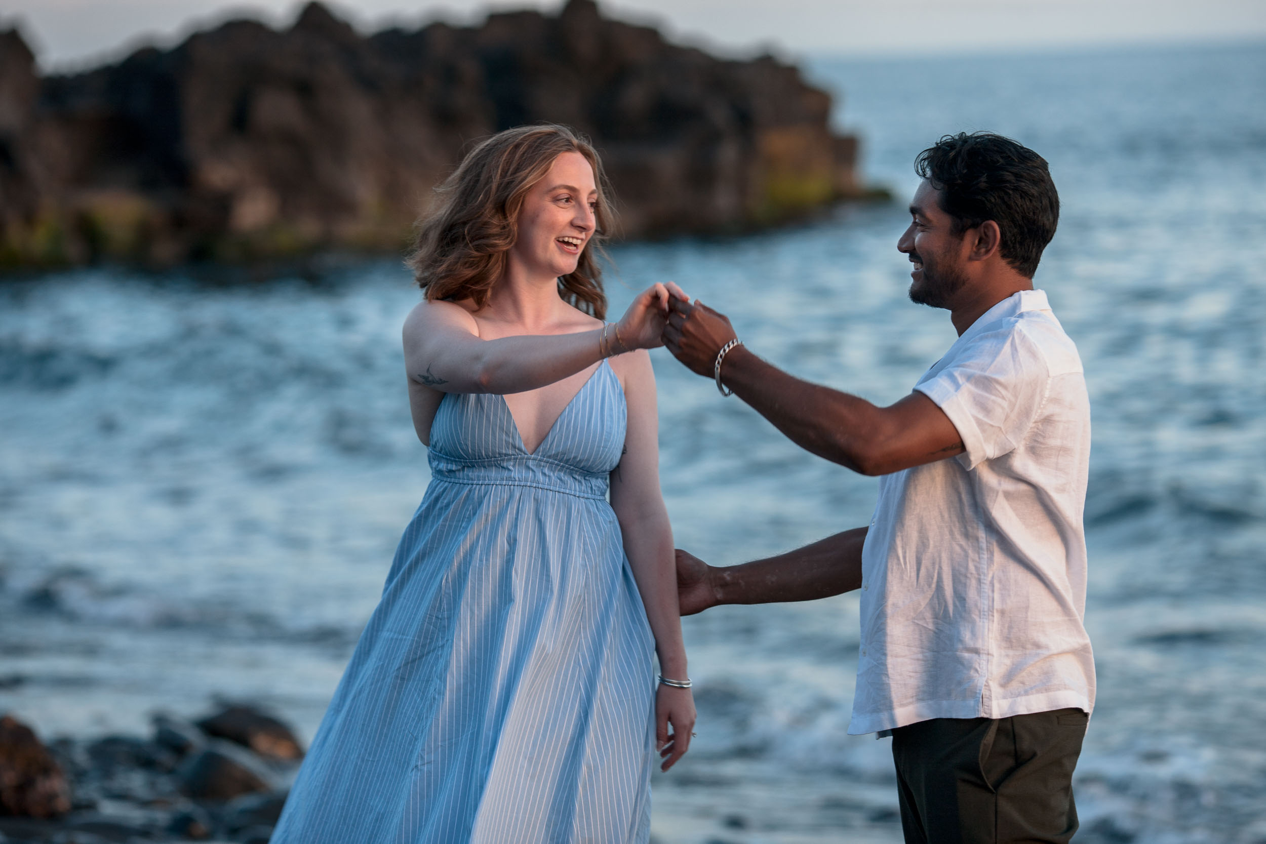 Engaged couple on rocky shore, Praia Formosa, Madeira