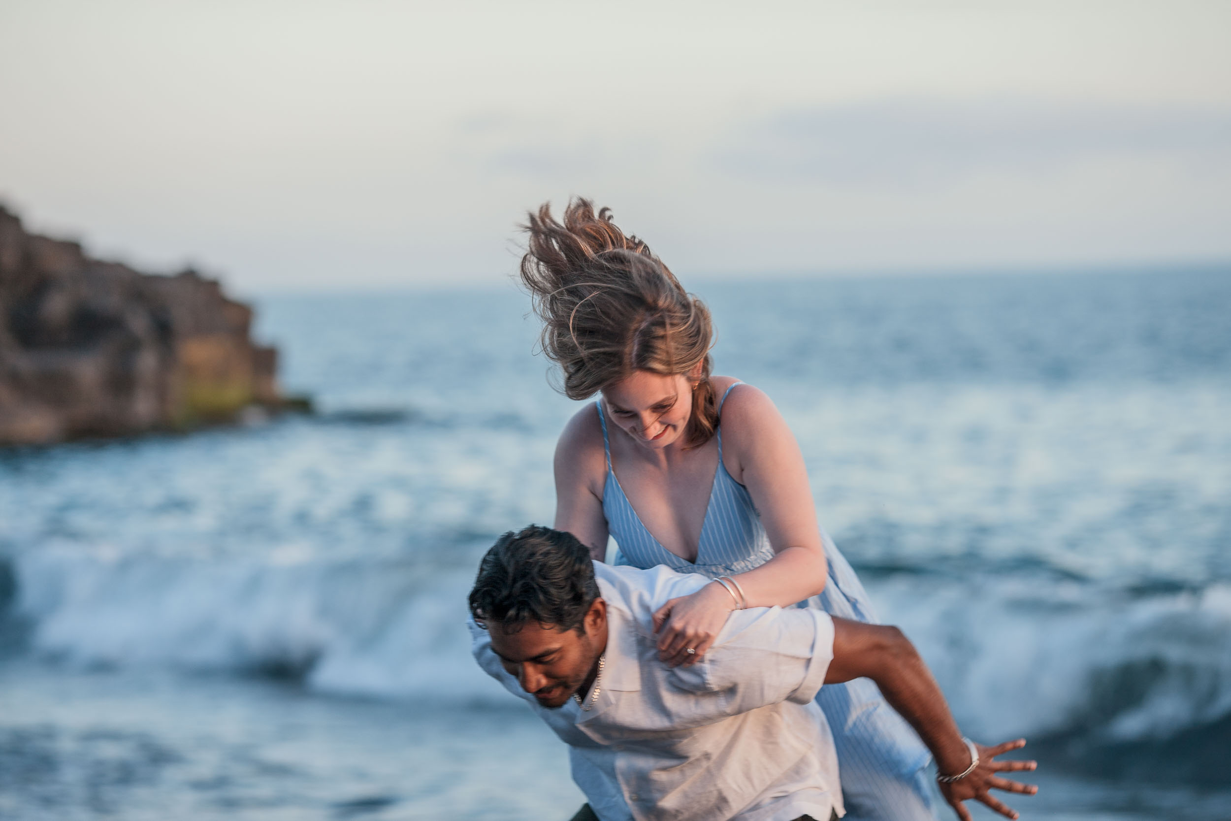 Couple wading in ocean shallows at dusk, Praia Formosa, Madeira