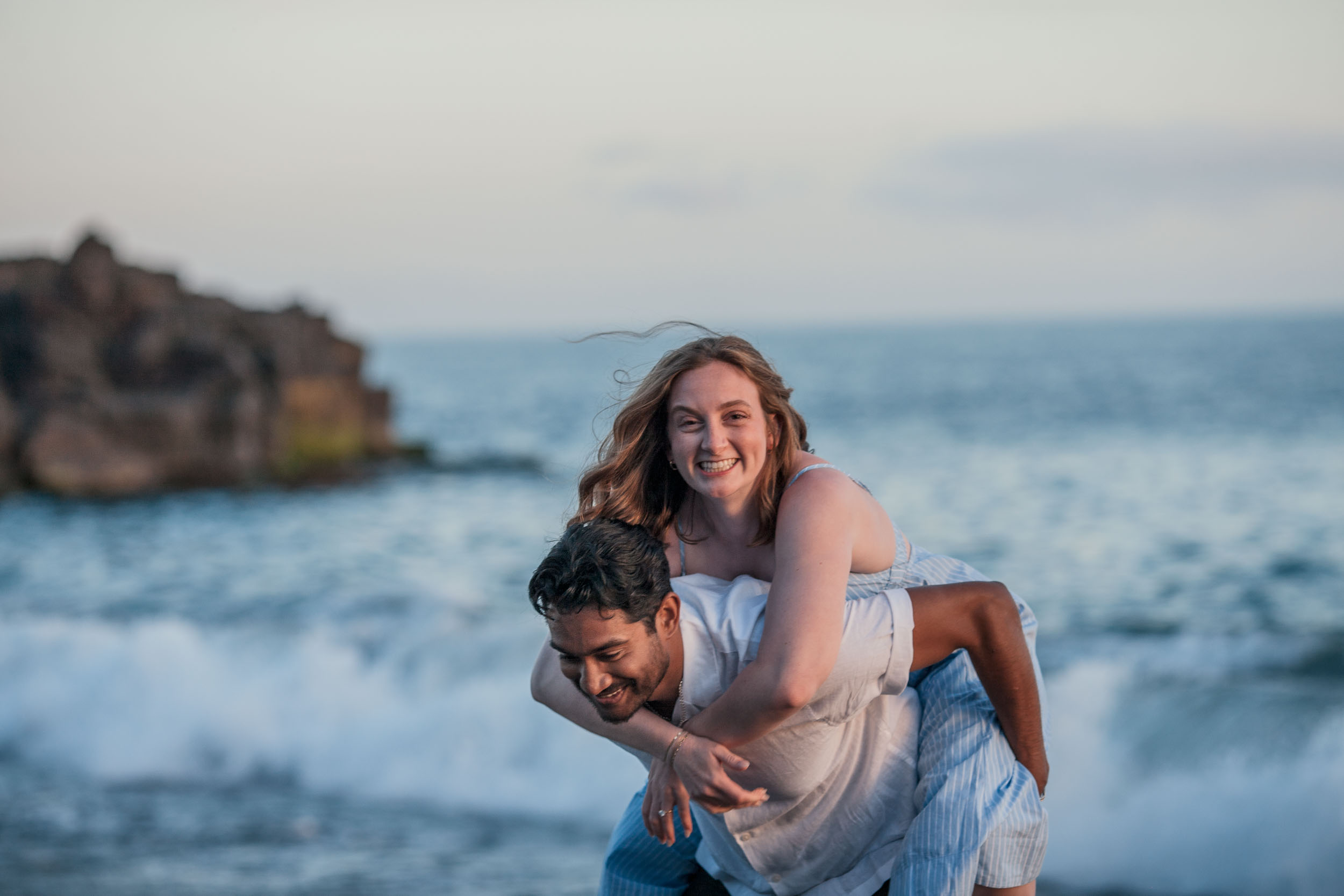 Couple on black volcanic rocks at Praia Formosa, Madeira