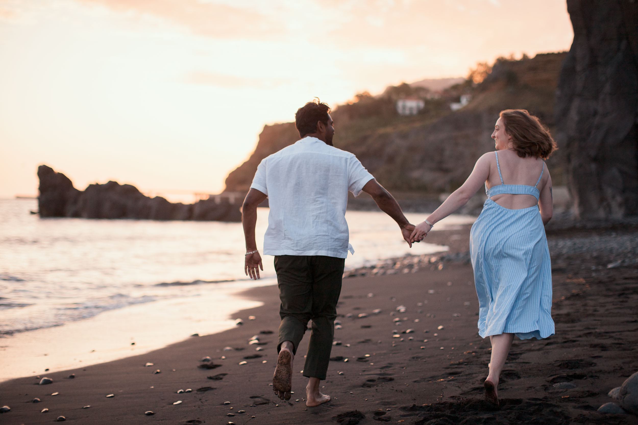Couple holding hands at Atlantic shore, Praia Formosa, Madeira