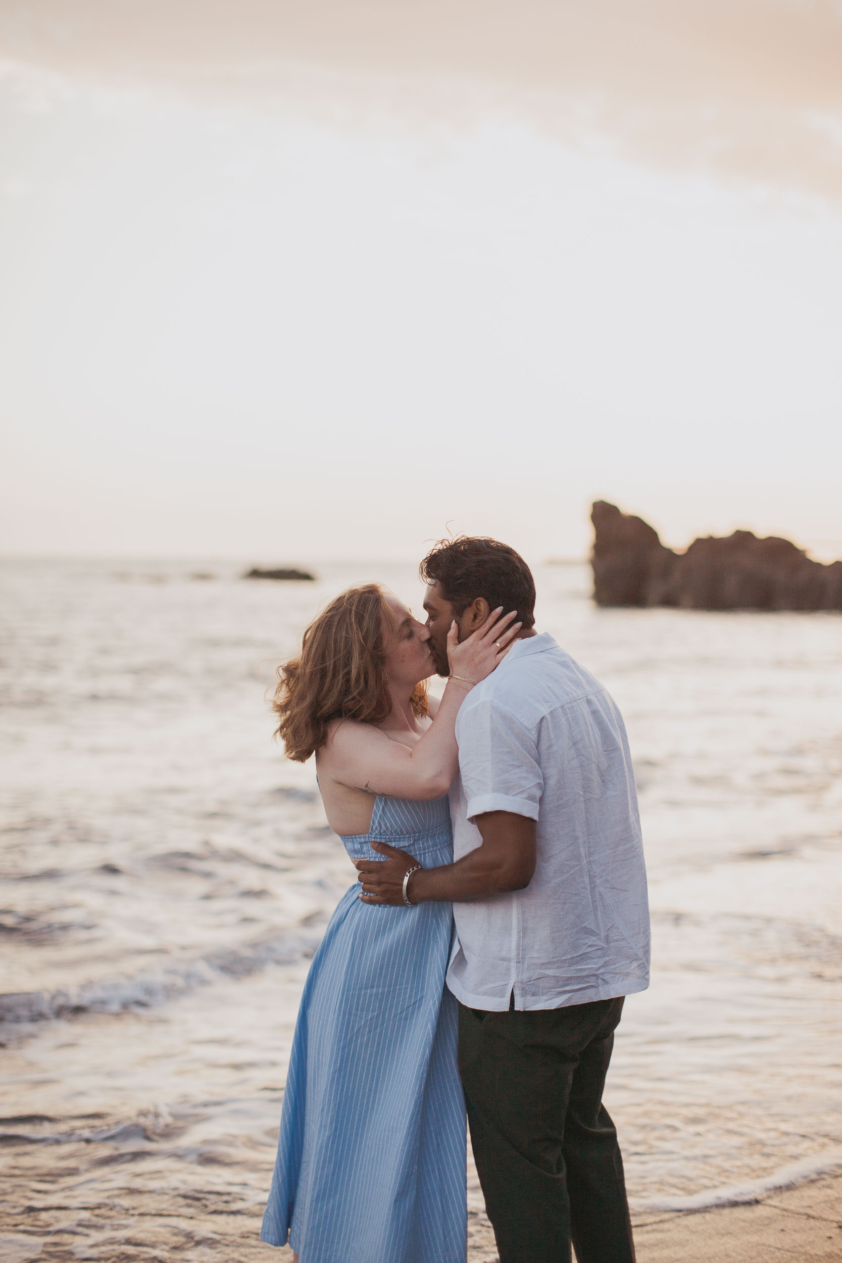 Couple wading in ocean shallows at dusk, Praia Formosa, Madeira