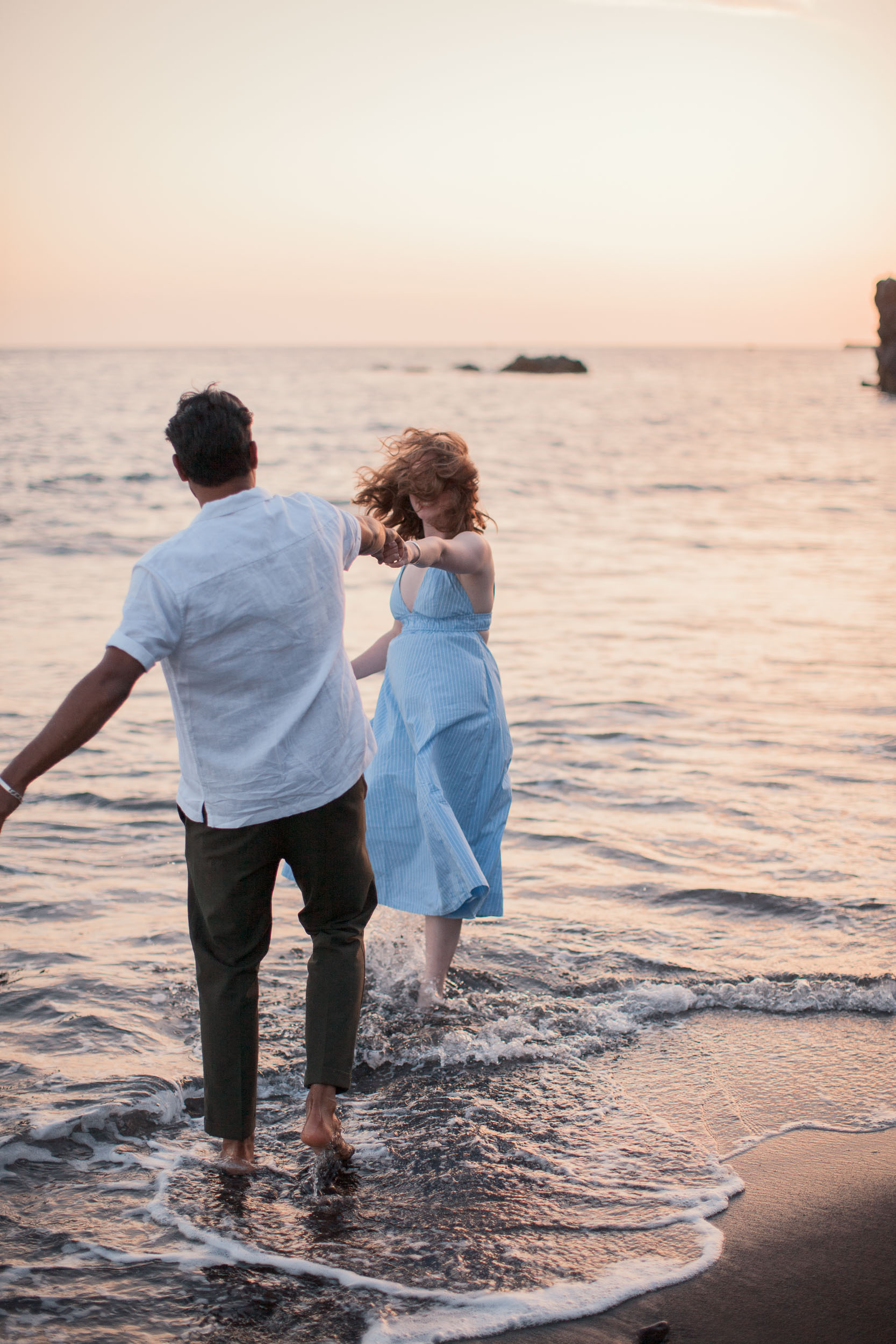 Couple on black volcanic rocks at Praia Formosa, Madeira