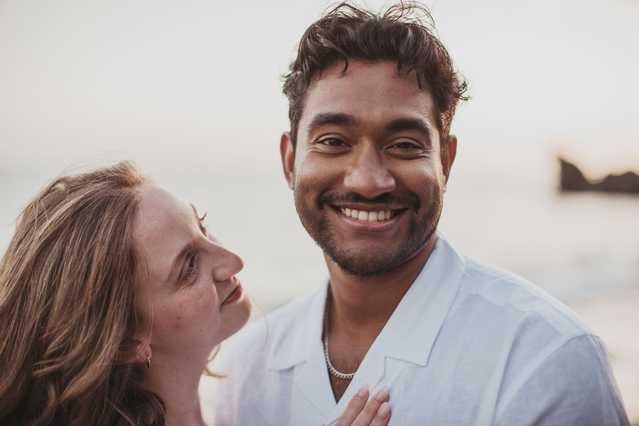 Engaged couple on rocky shore, Praia Formosa, Madeira