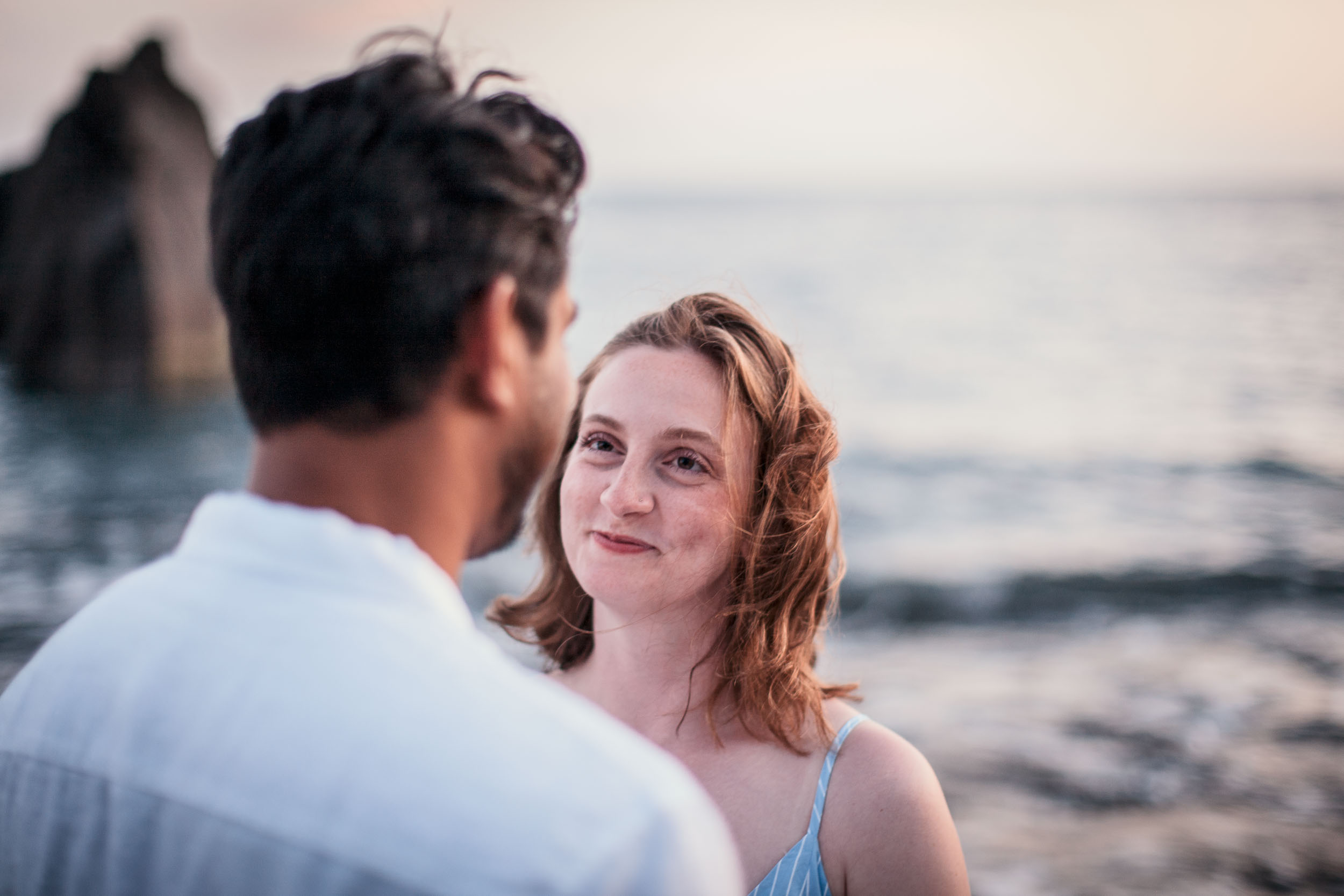 Woman with auburn hair looking at partner in soft dusk light, Praia Formosa, Madeira