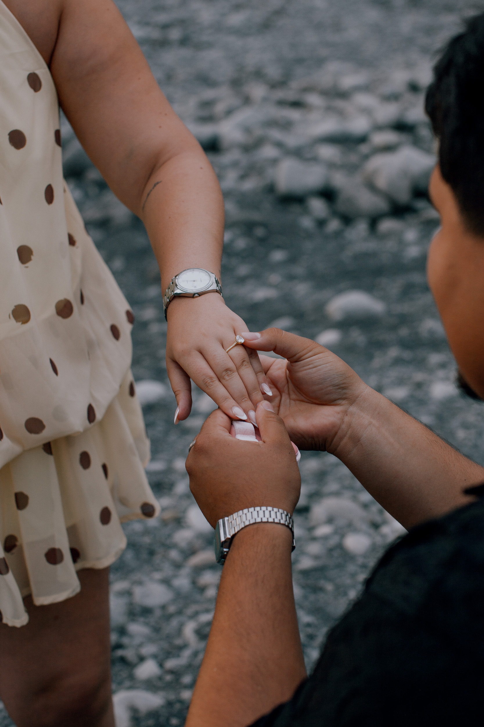 Close-up of the ring going onto her hand over the polka-dot dress, proposal on Madeira
