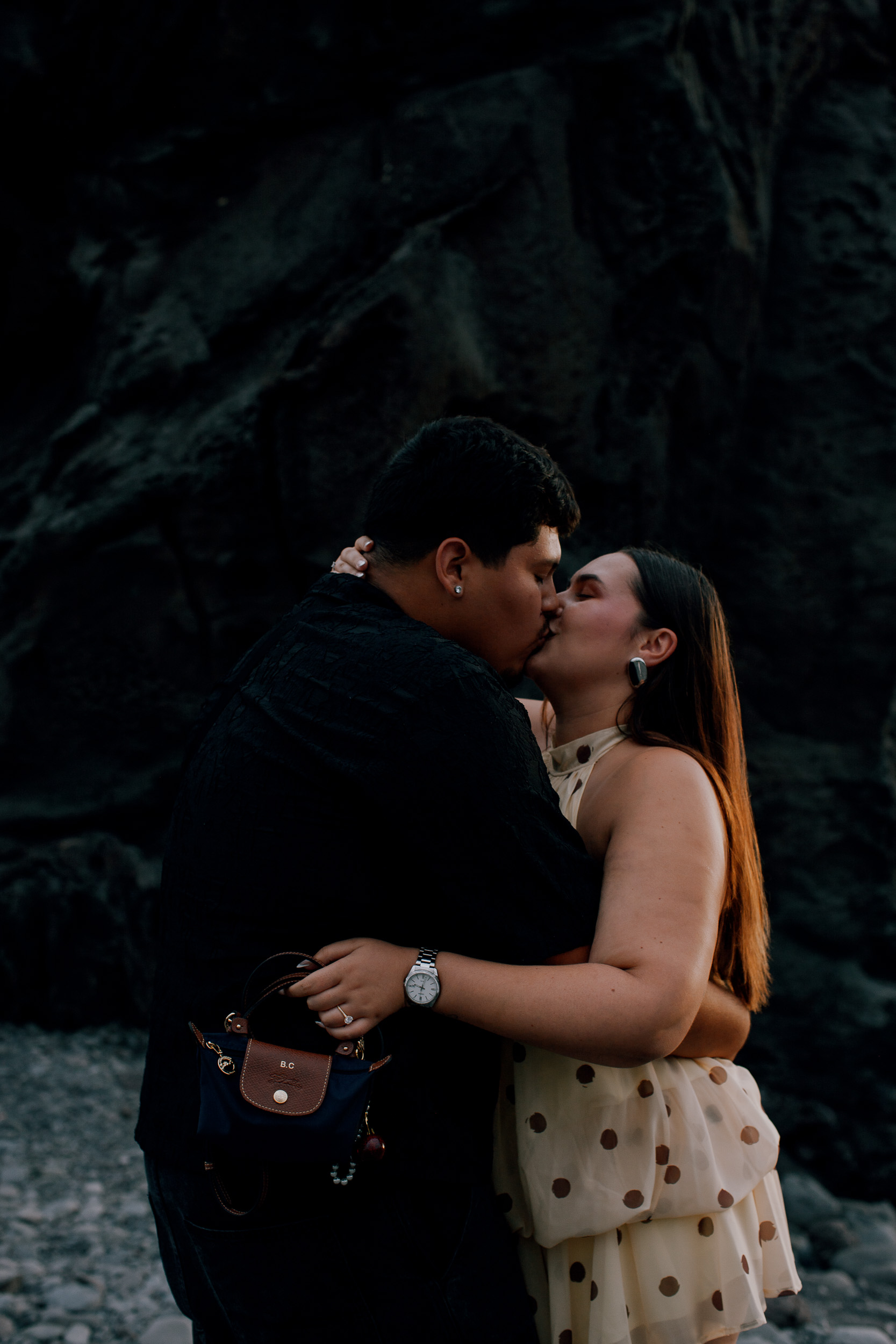 First kiss as an engaged couple beneath the volcanic rock at Praia Formosa, Madeira