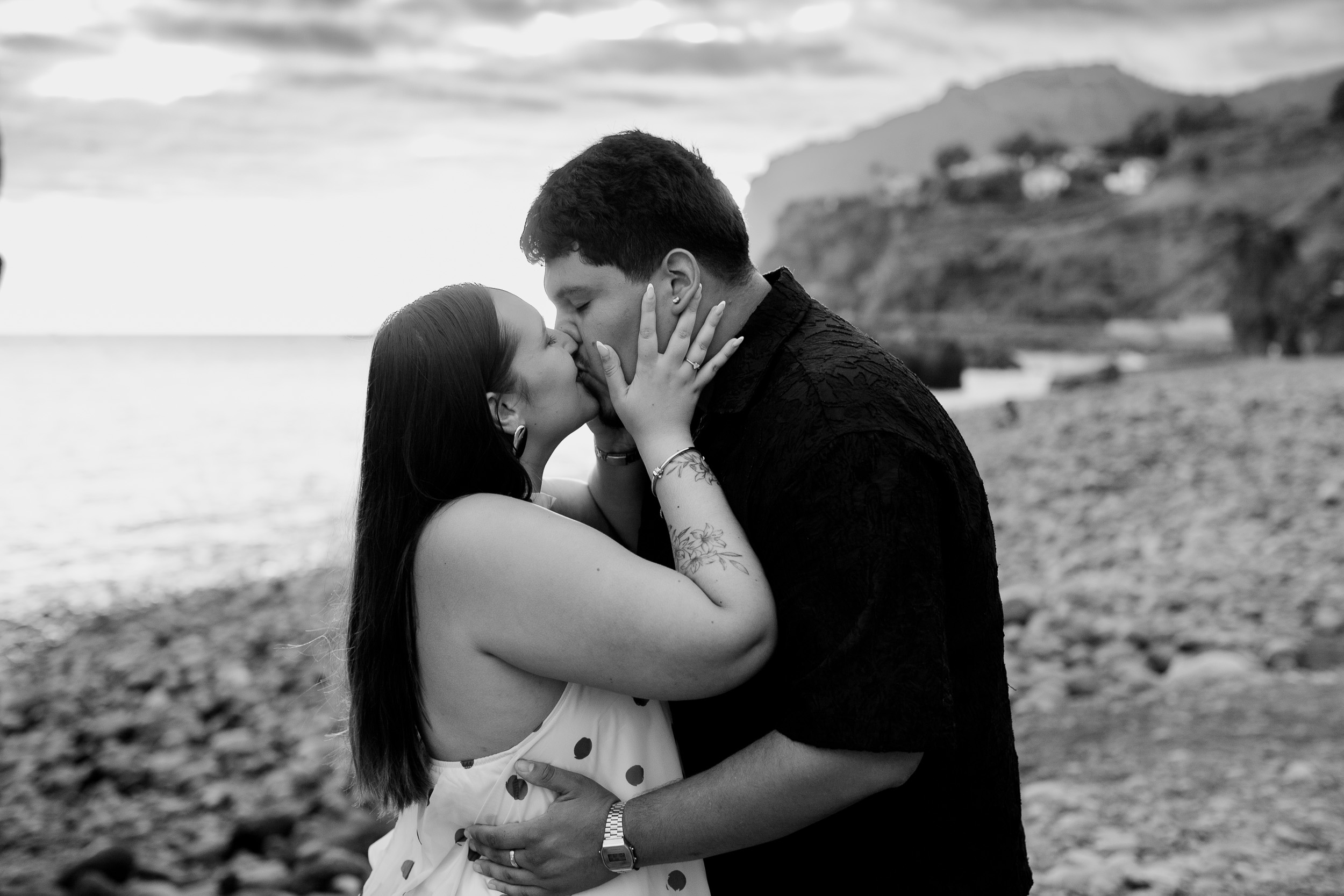Black and white kiss on the stones of Praia Formosa moments after the engagement, Madeira