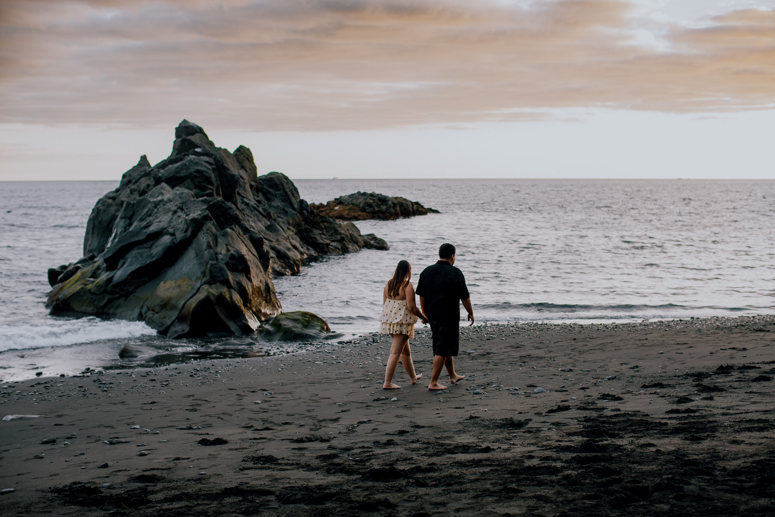 Small against the rock and the evening ocean, newly engaged at Praia Formosa, Madeira