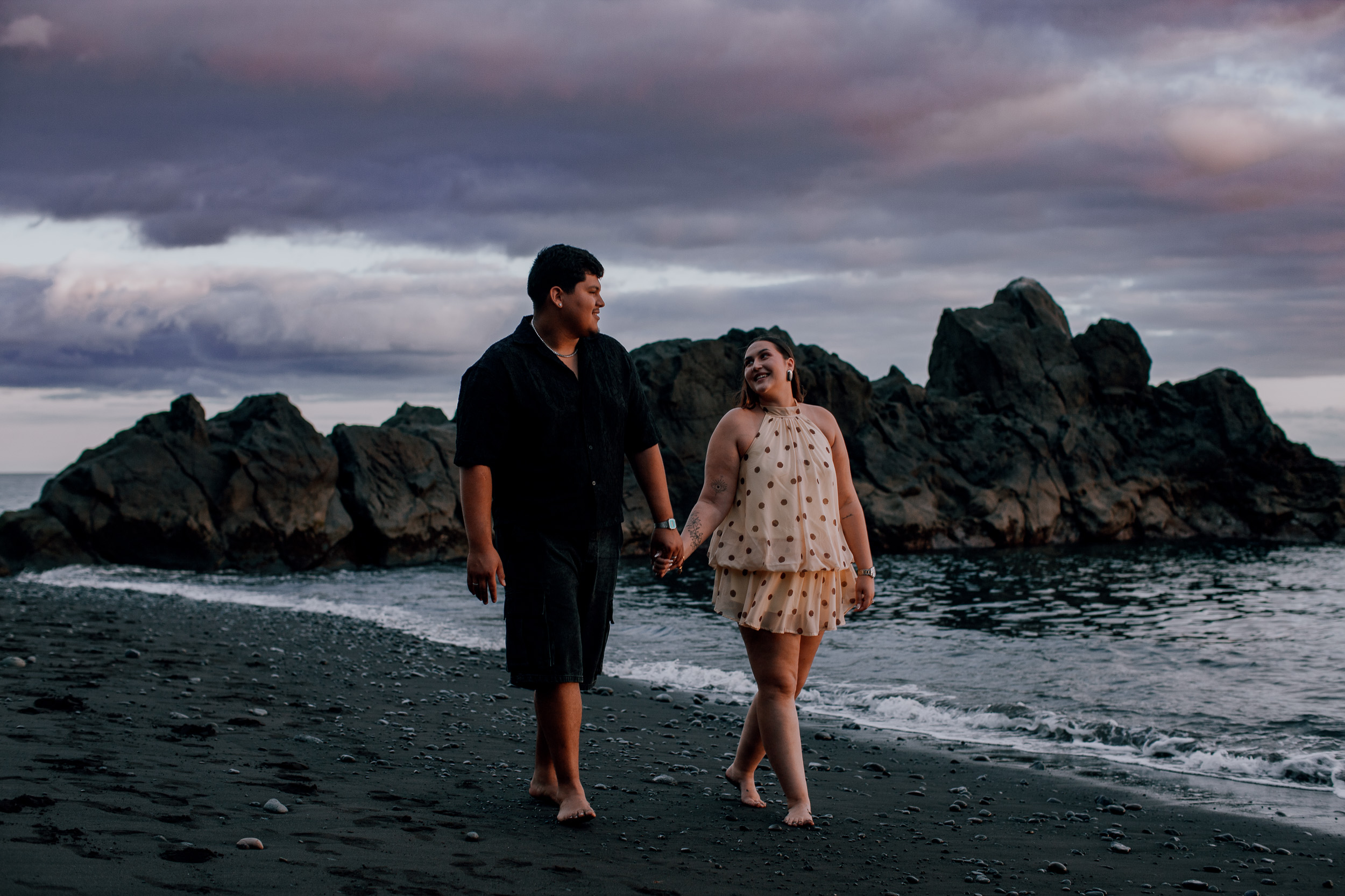 Strolling the beach together under a violet evening sky, engaged couple on Madeira
