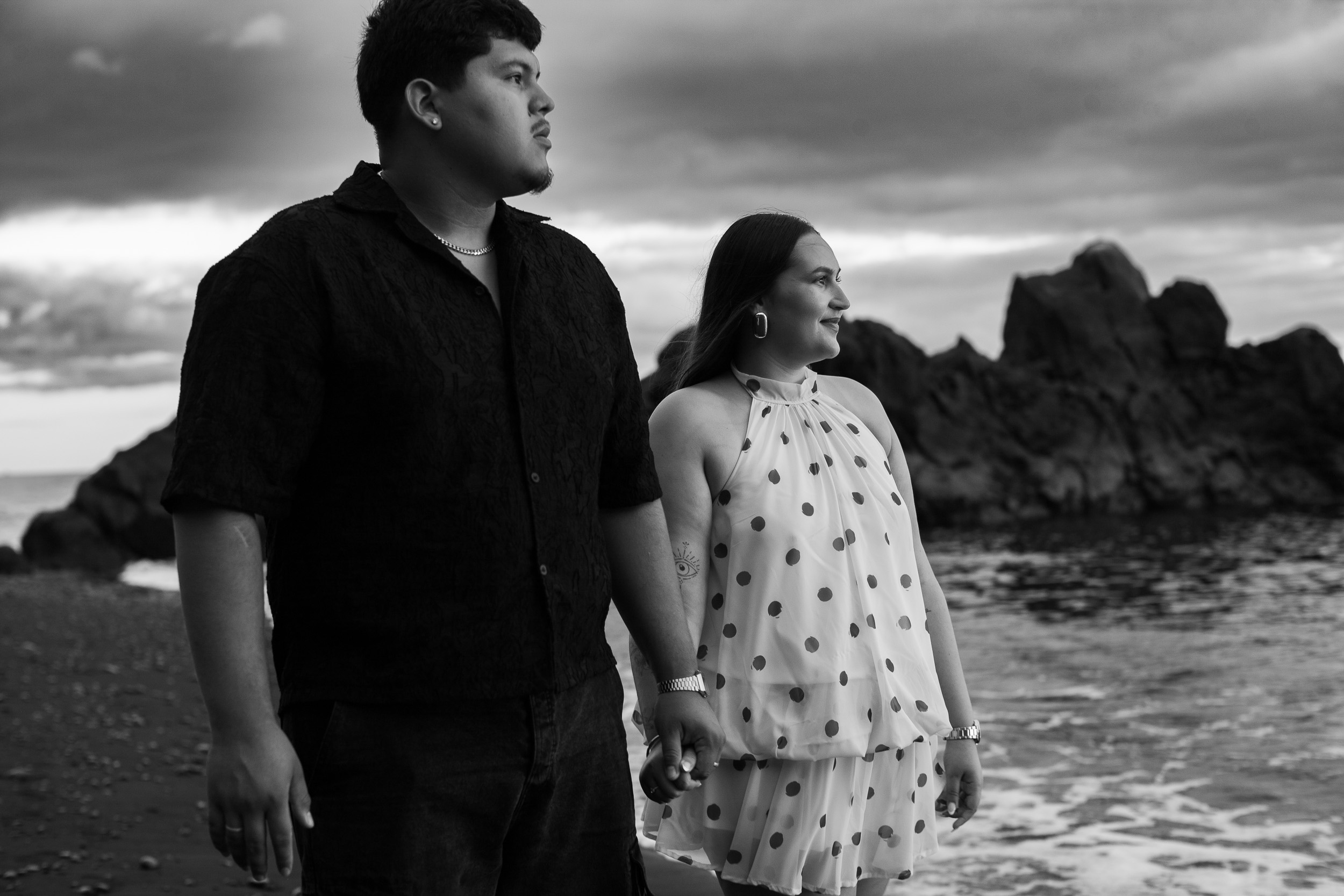Black and white portrait by the rocks, her polka-dot dress catching the wind, Madeira