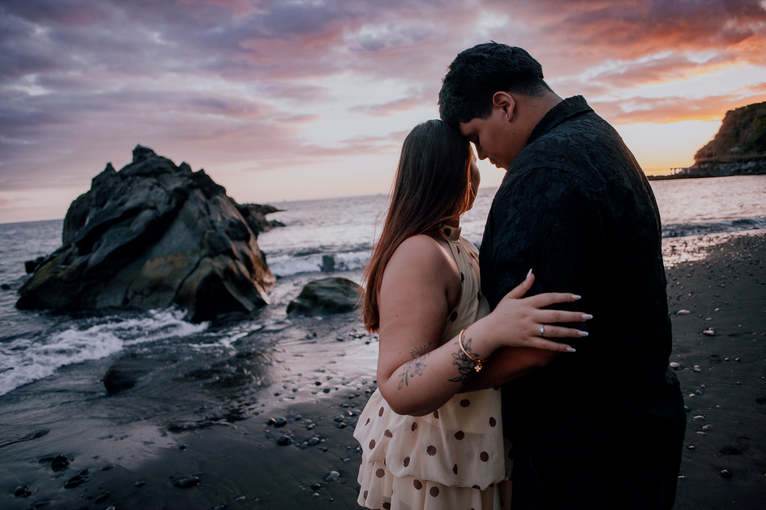 Embracing by the sea stack under sunset clouds, engagement evening on Madeira