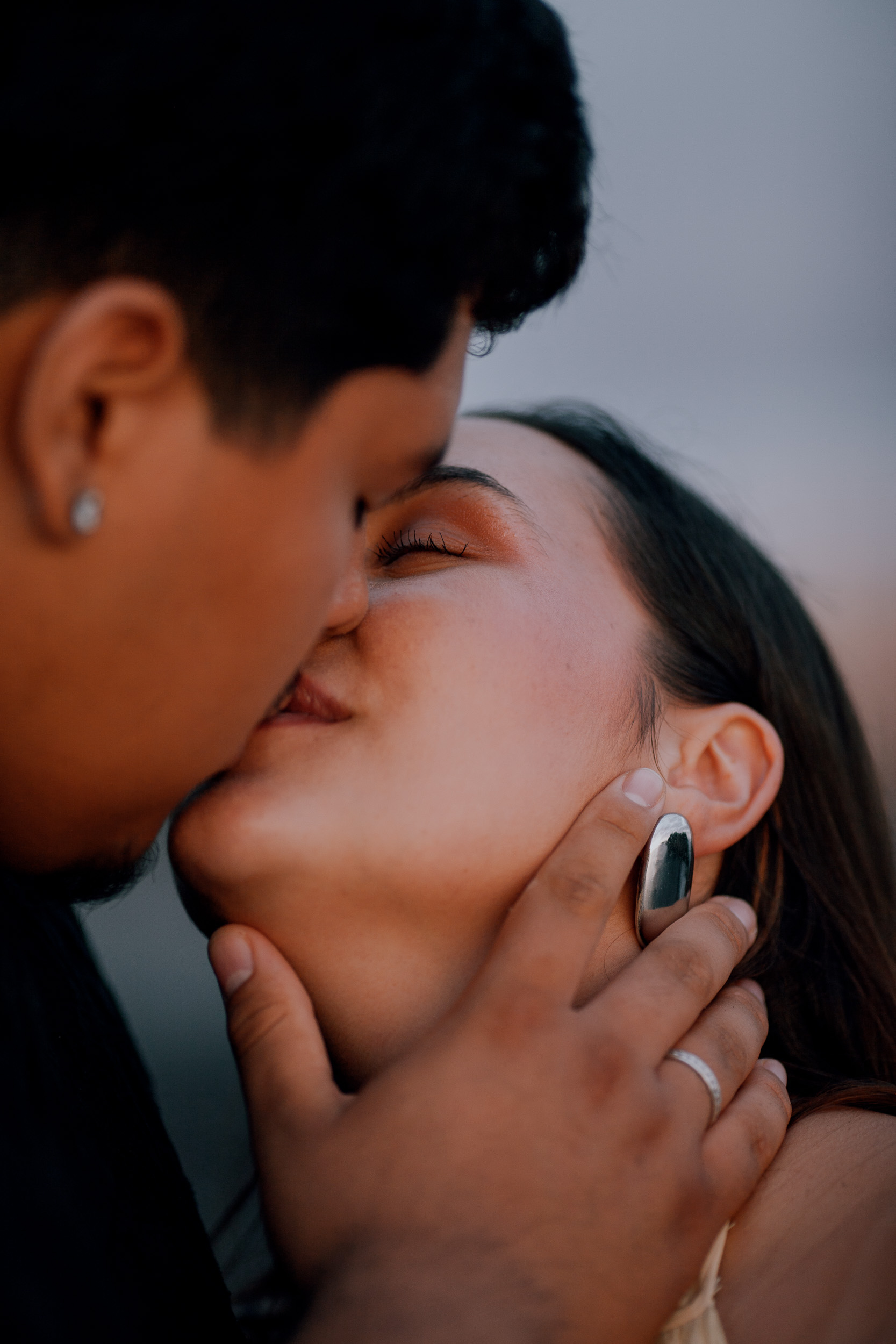 Close portrait of her smile with the silver earring at dusk, Madeira