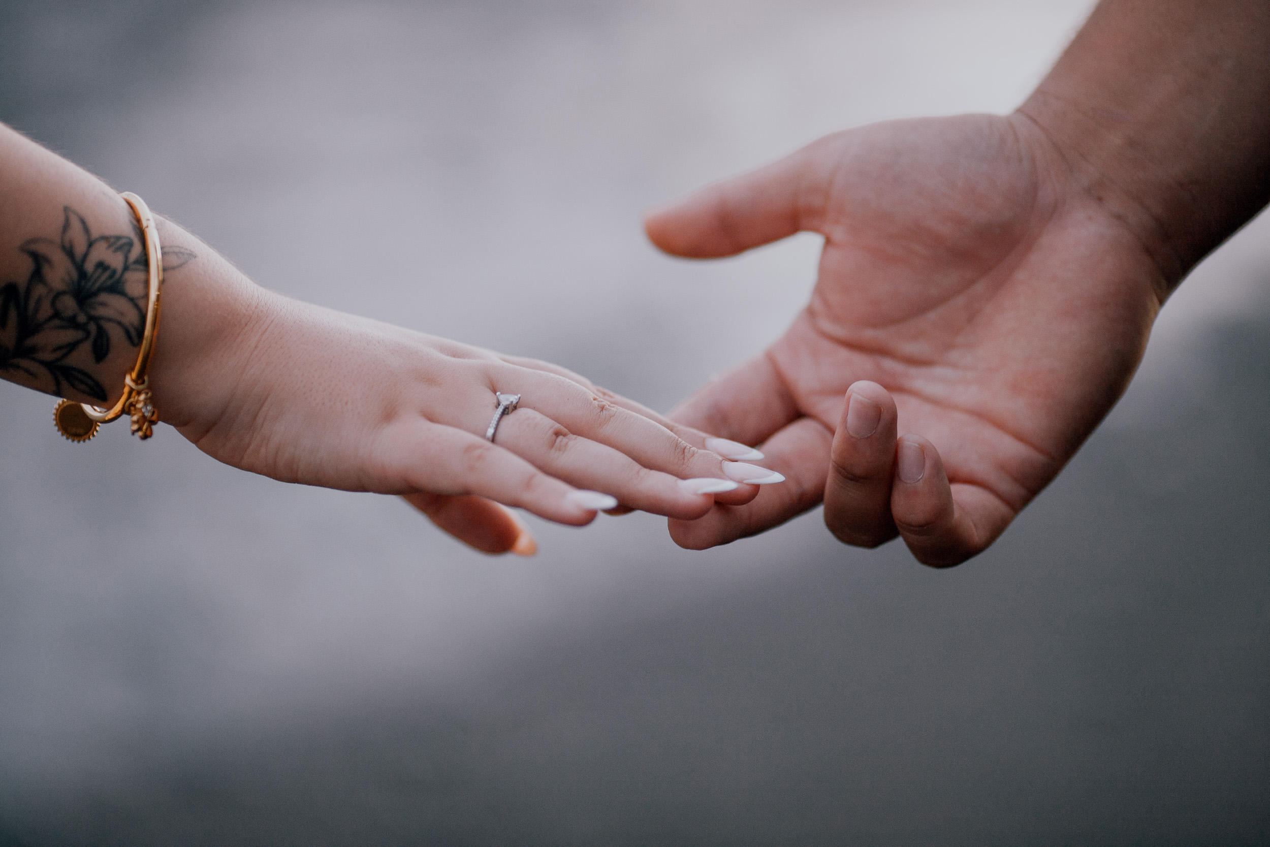 Her hand with the ring resting in his open palm on the beach, Madeira