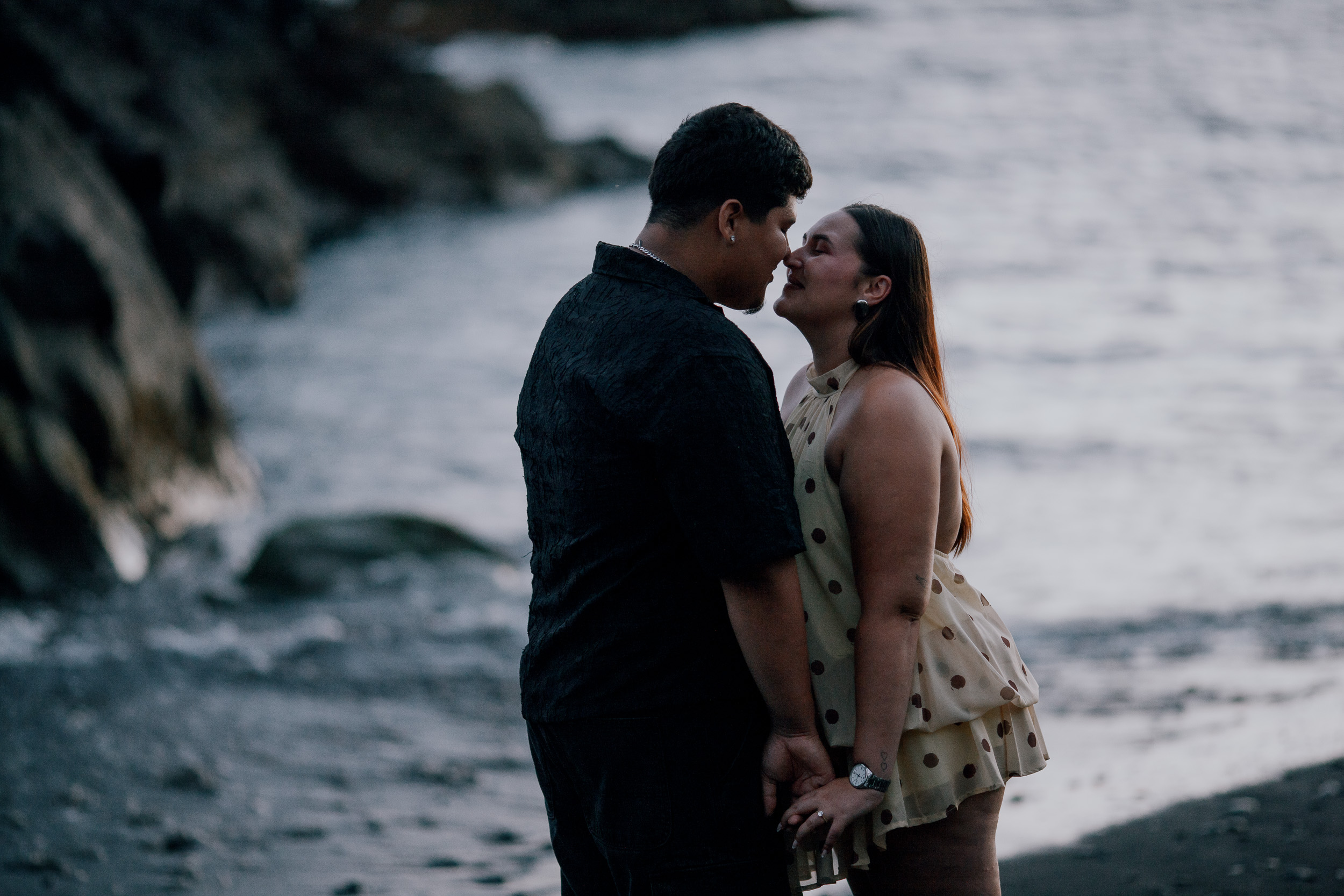 Kissing at the waterline in the last light of the engagement evening, Madeira