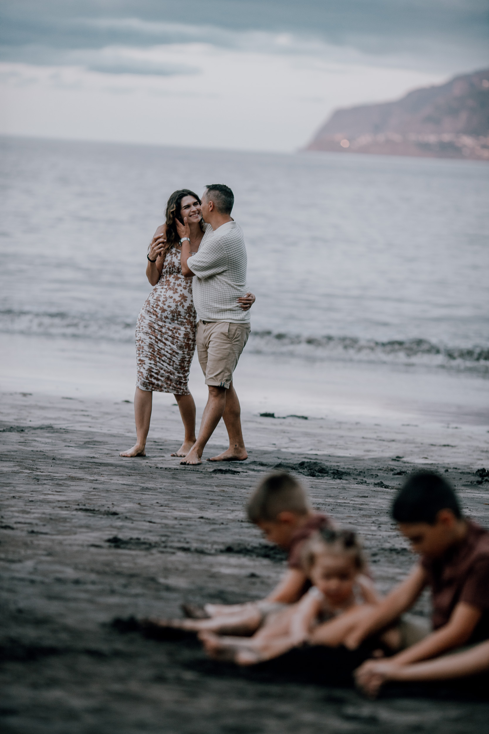 Mum and dad close as the light drops, kids playing on, Seixal Beach, Madeira