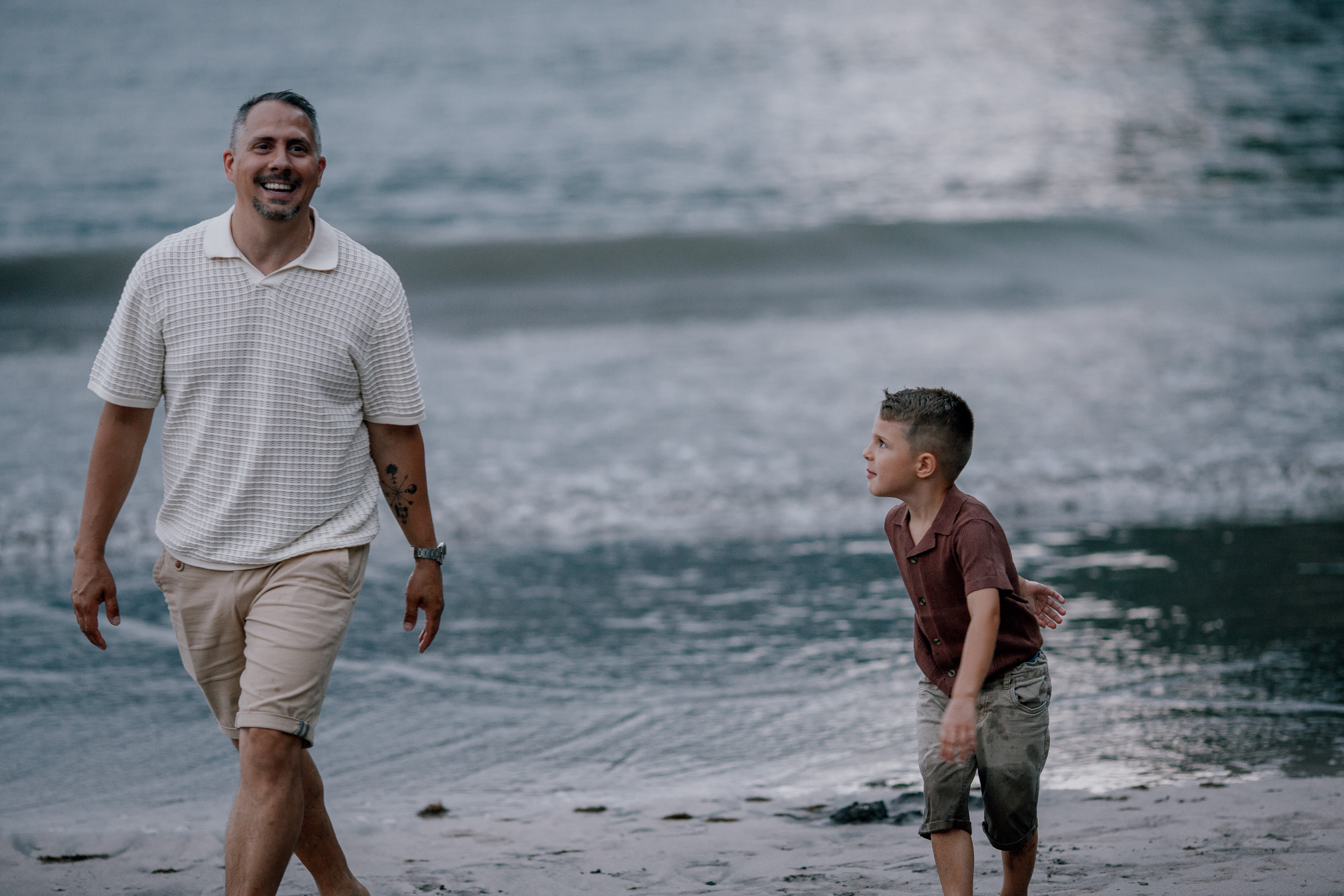 Dad high-fiving the boy running out of the surf, Seixal Beach, Madeira