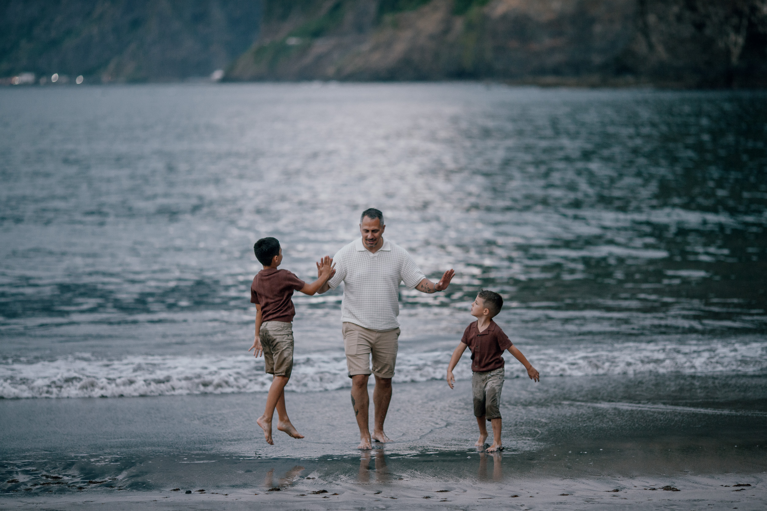 Dad and the boys charging into the waves together, Seixal Beach, Madeira