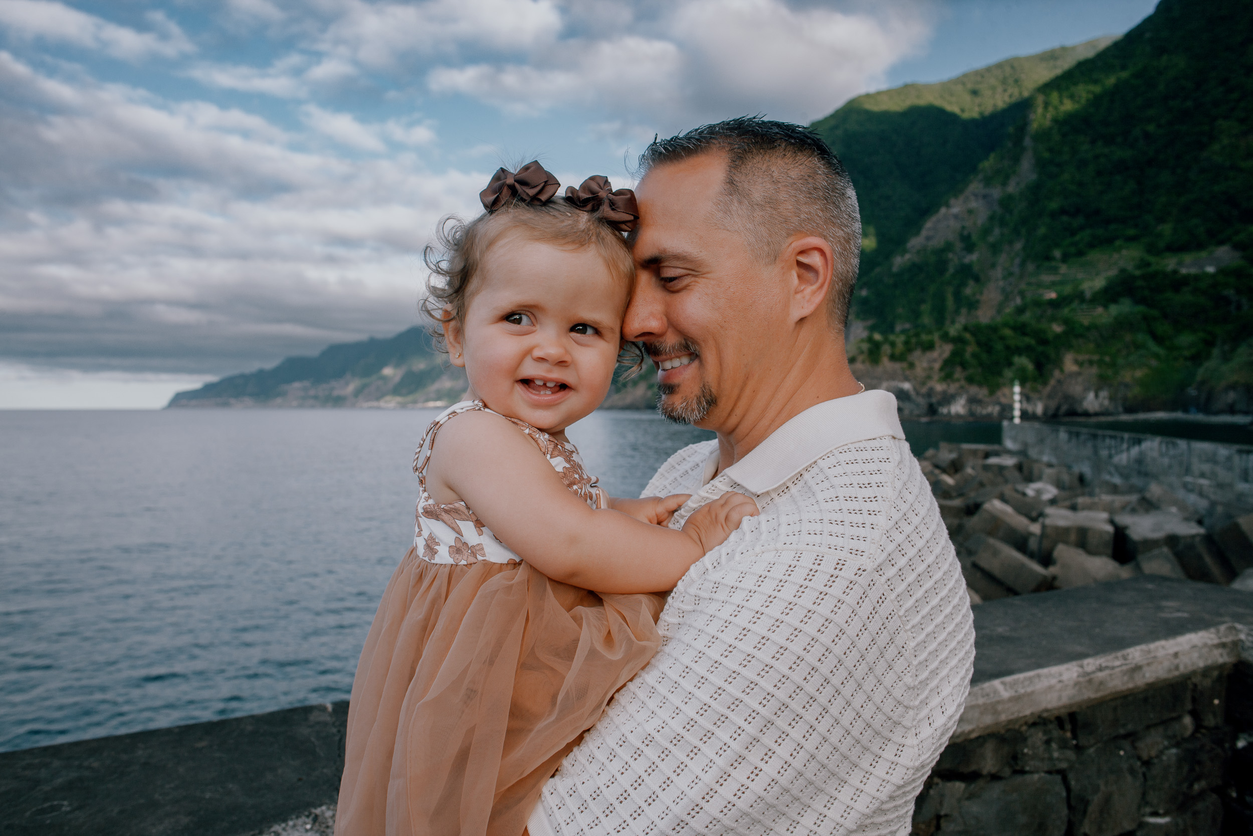 The baby laughing in her father's arms above the bay, Seixal, Madeira