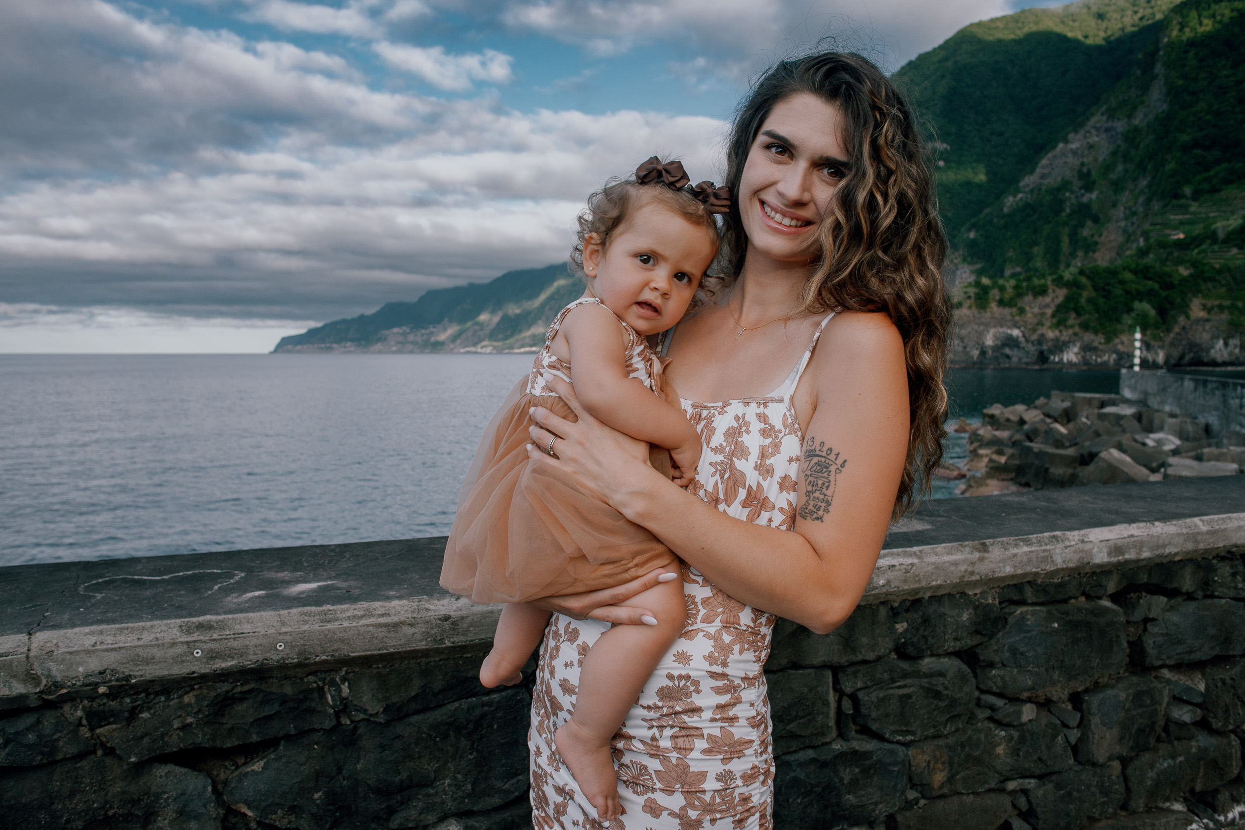 Mother holding the baby girl with the harbor behind, Seixal, Madeira