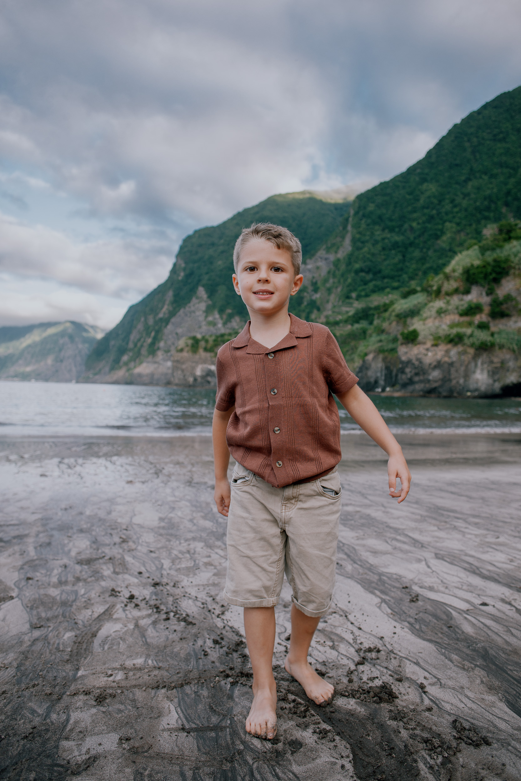 The older boy walking the wet sand alone, cliffs behind, Seixal, Madeira