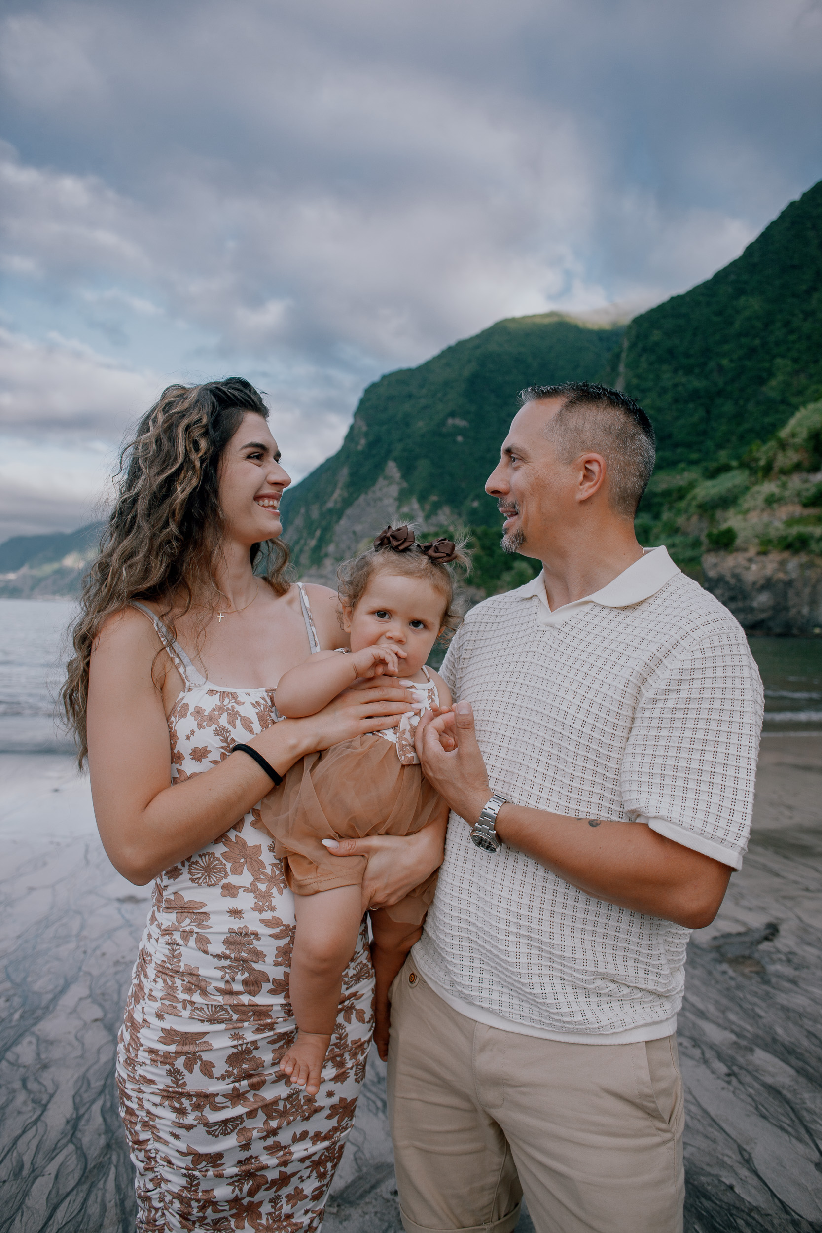 Parents laughing with the baby by the water, Seixal Beach, Madeira