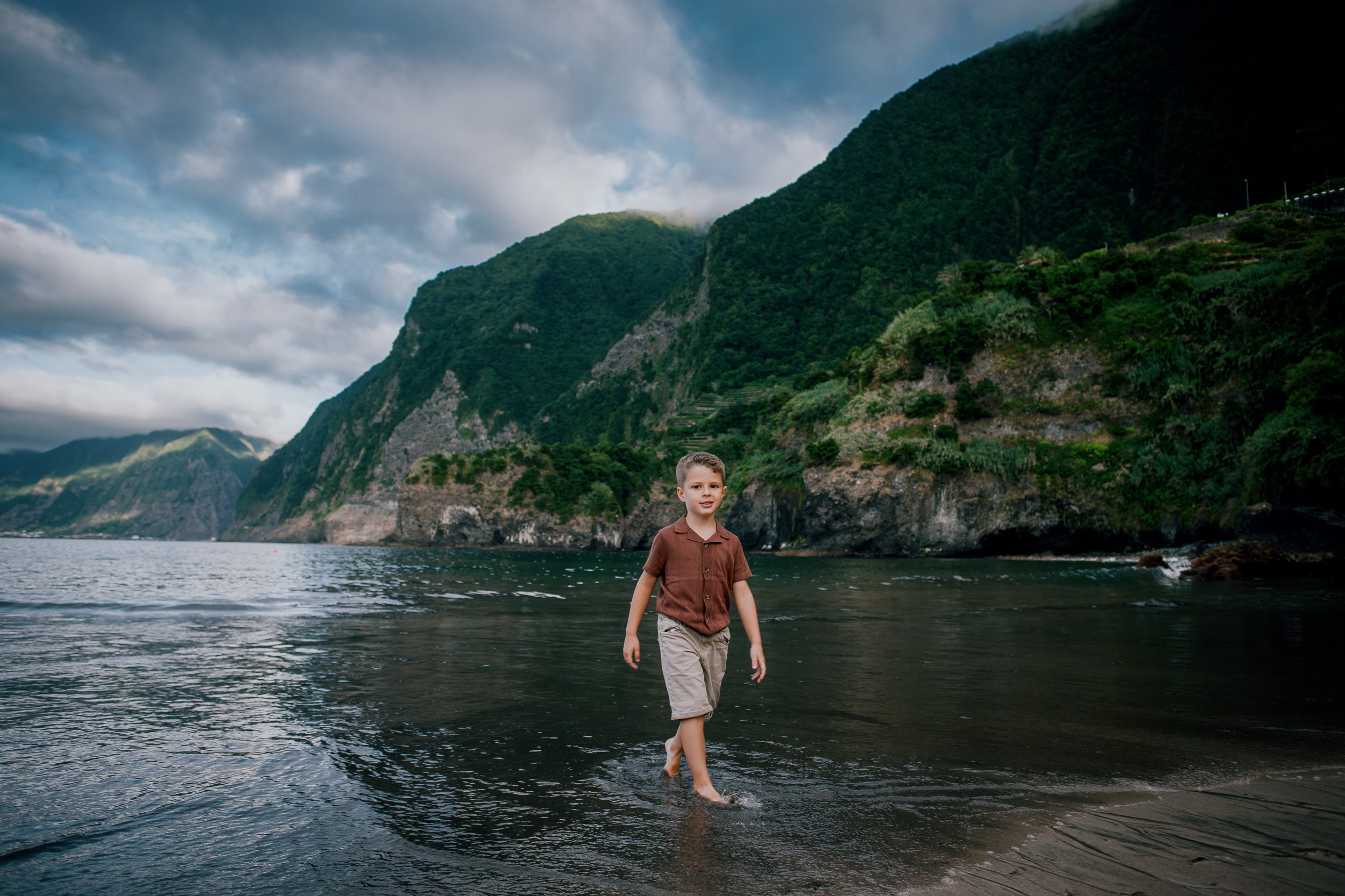 The little boy wading in the shallows below the cliffs, Seixal, Madeira