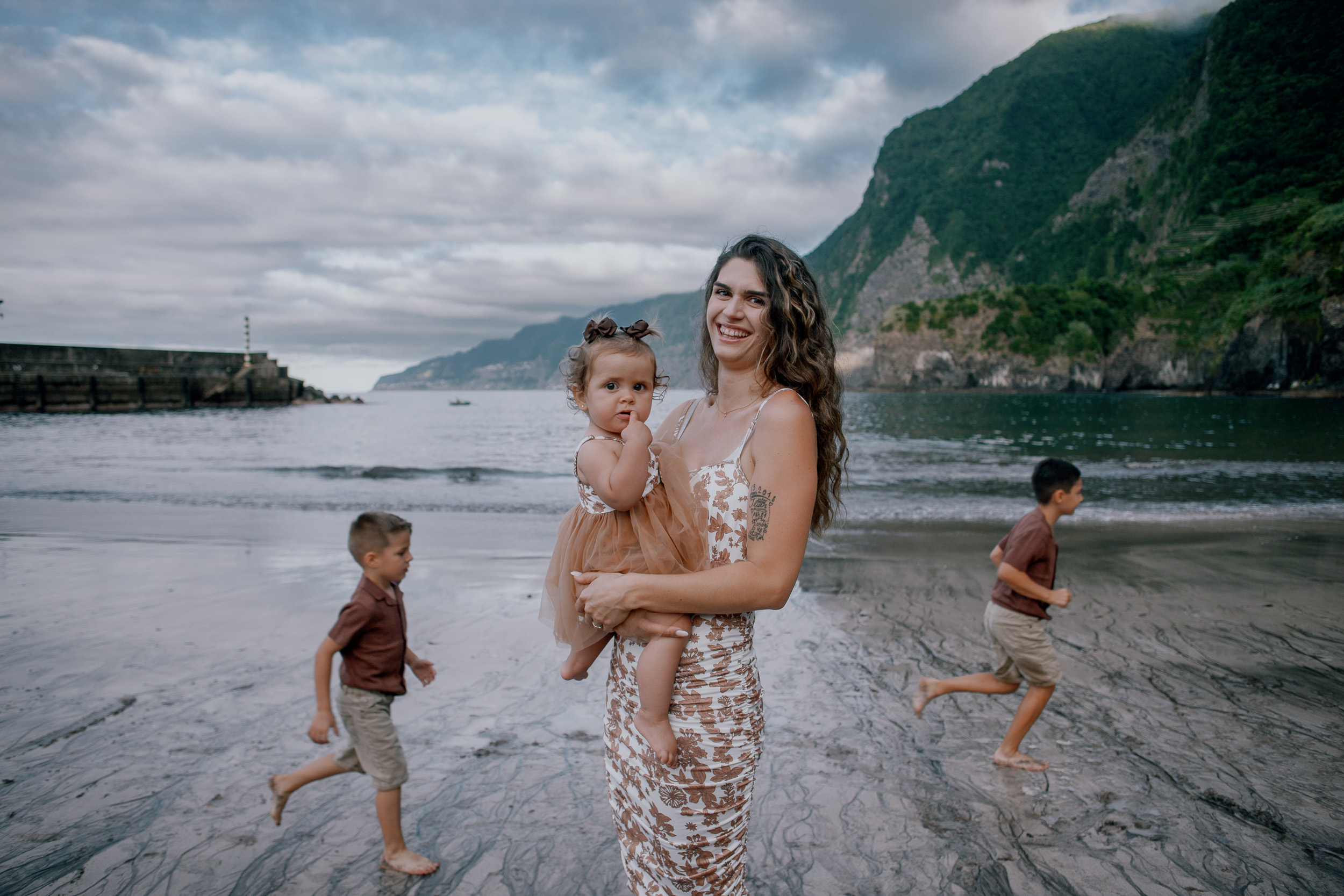 The boys grinning in front of their parents on the beach, Seixal, Madeira