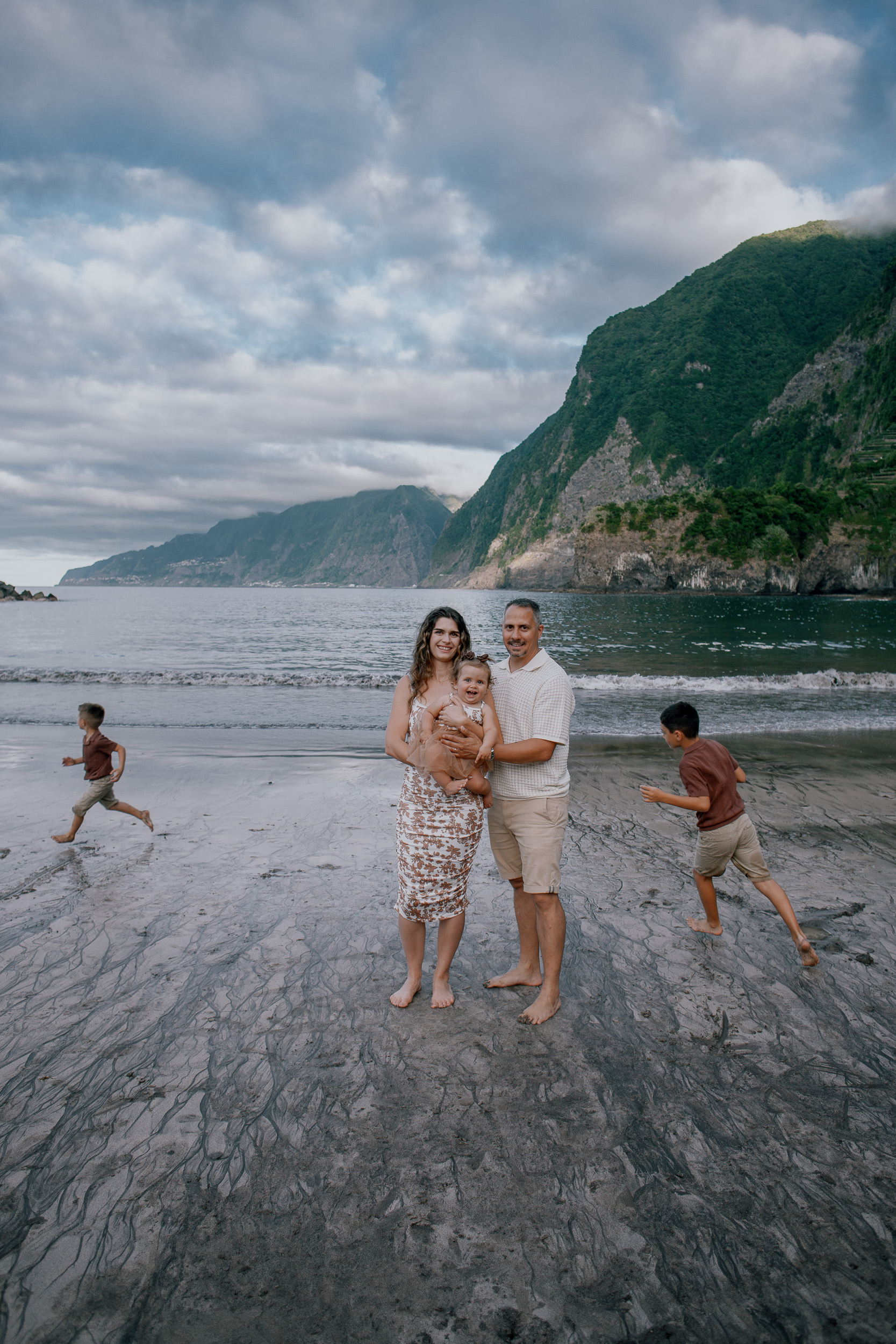 Sandy hand reaching to the lens, family behind, Seixal Beach, Madeira