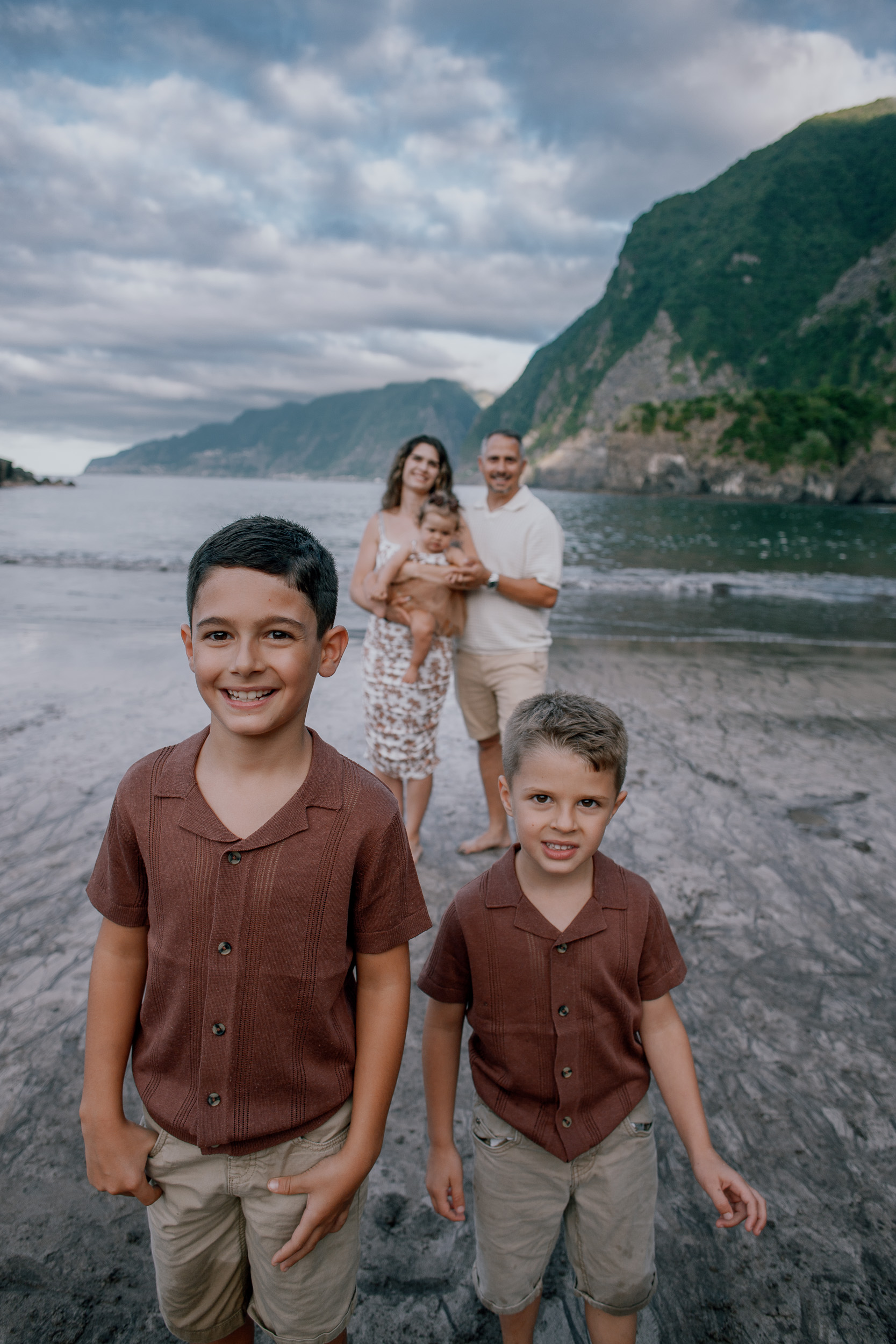The boys inspecting a rock together on the shore, Seixal, Madeira