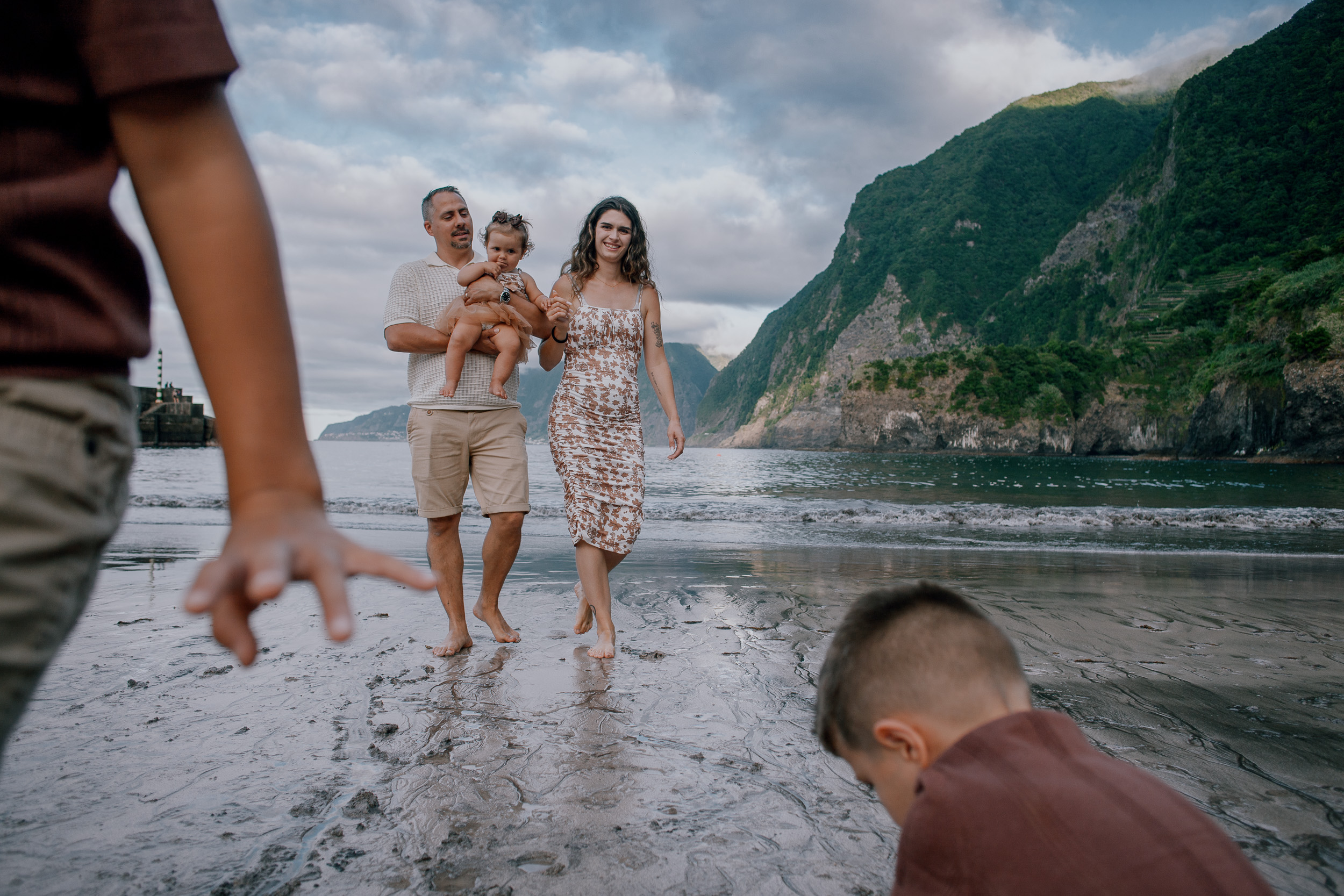 Dad tossing the younger boy into the air by the water, Seixal, Madeira