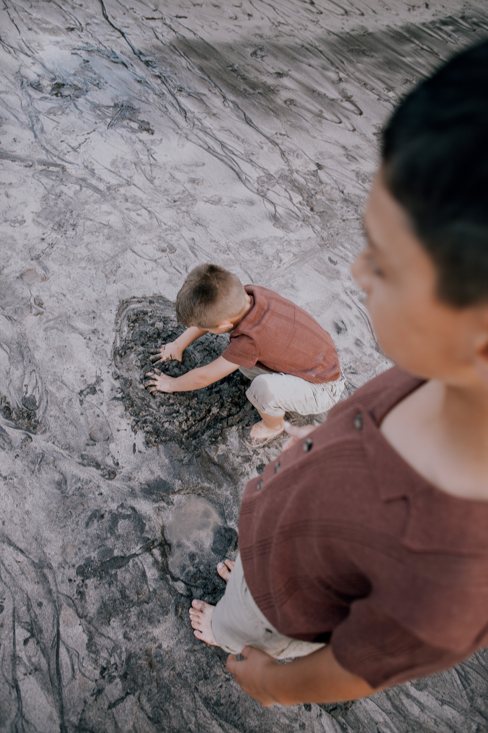 Father throwing his laughing son skyward at the shore, Seixal, Madeira