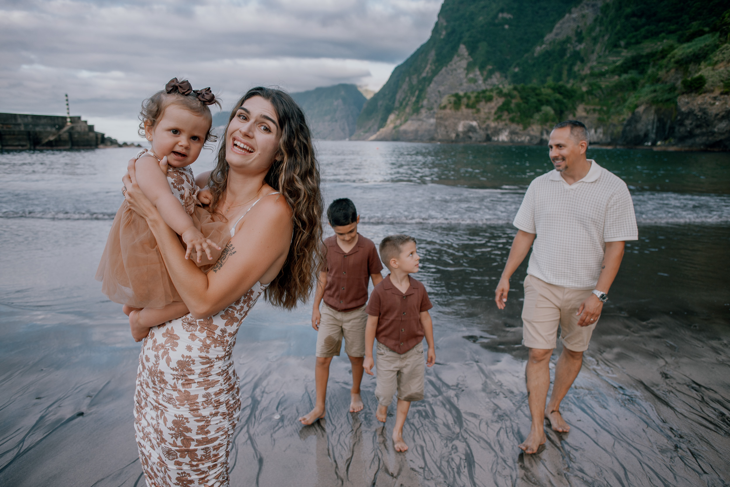 Mum with the baby laughing beside the family at the surf, Seixal, Madeira