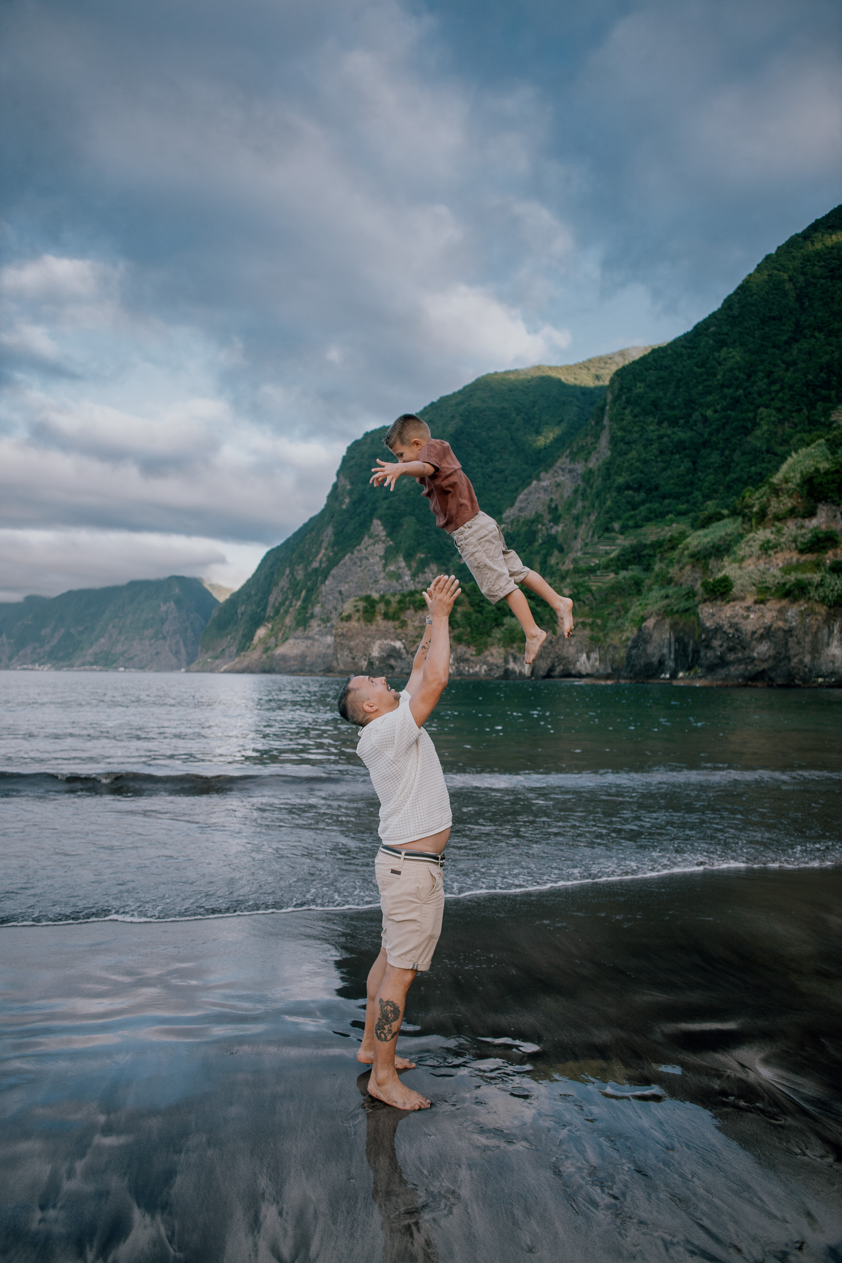 Dad launching his son into the air over the shallows, Seixal Beach, Madeira