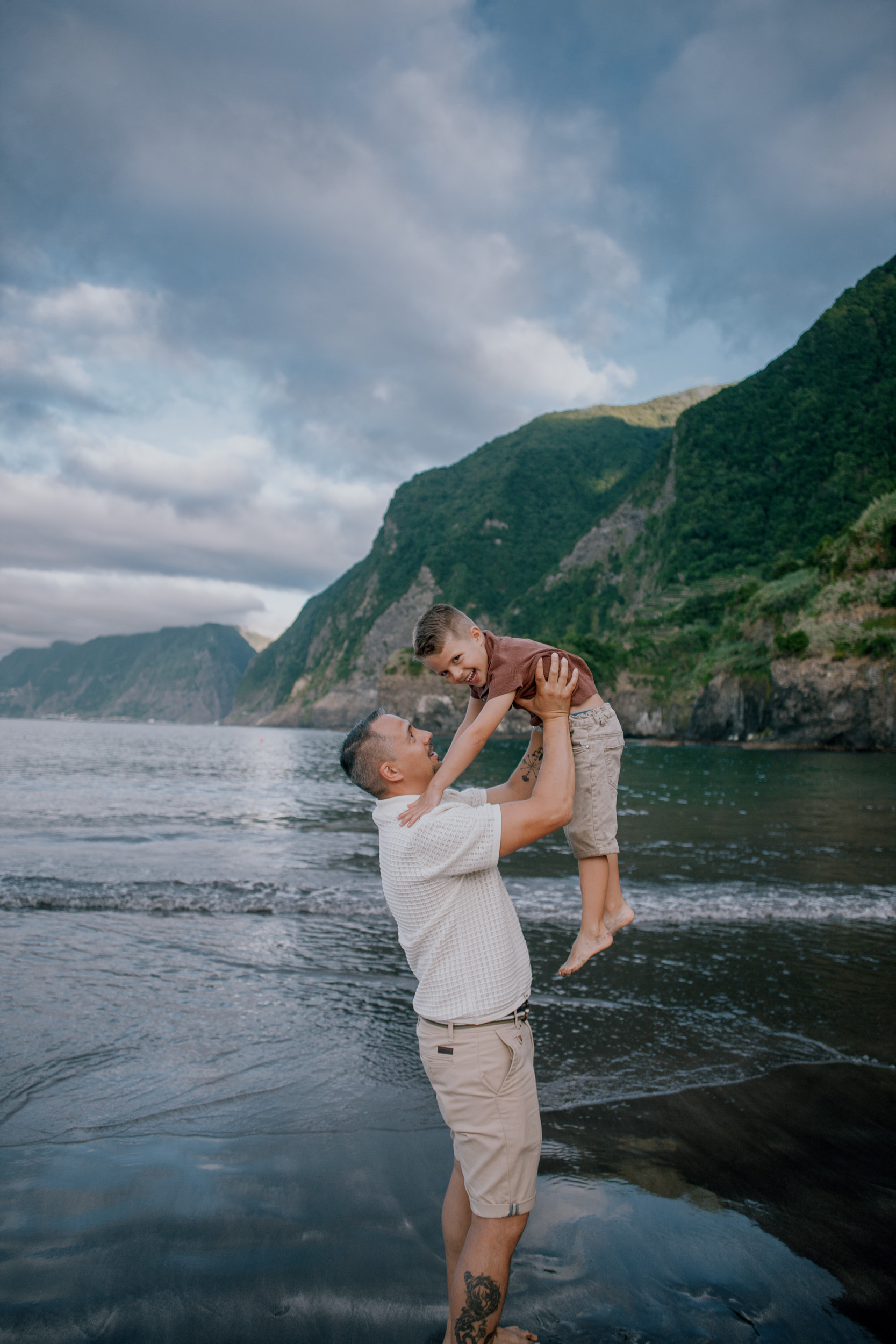 The boy flying in his father's arms above the water, Seixal, Madeira