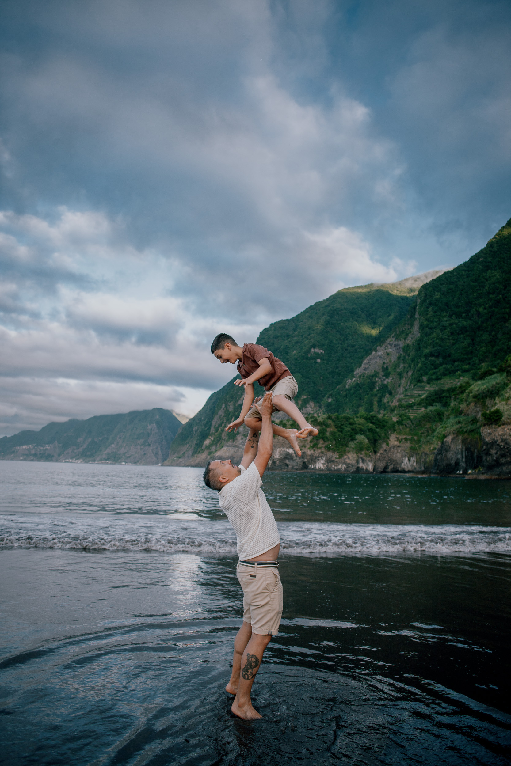 Father swinging the boy over the surf, Seixal Beach, Madeira