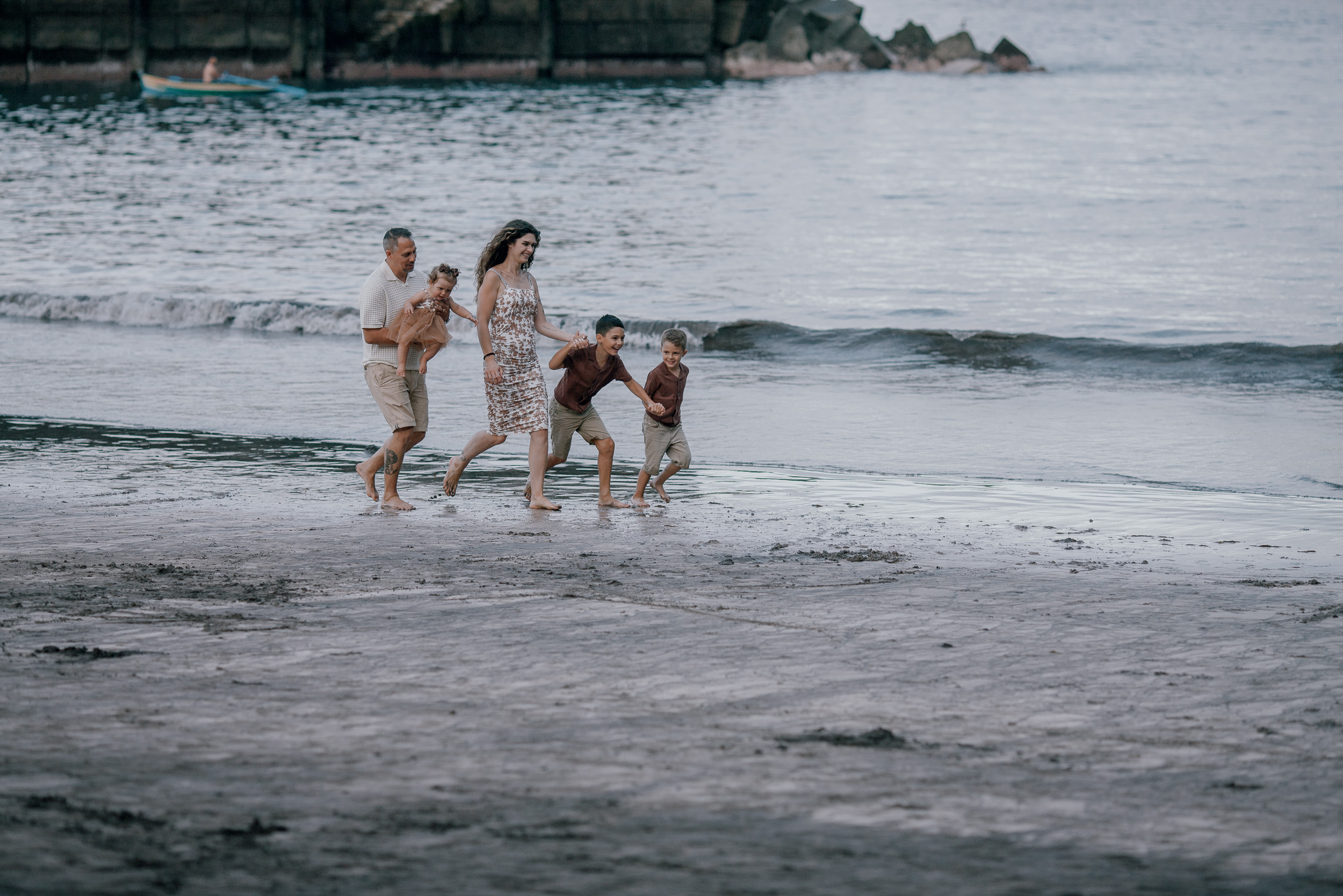 The family walking the empty beach at dusk, Seixal, Madeira