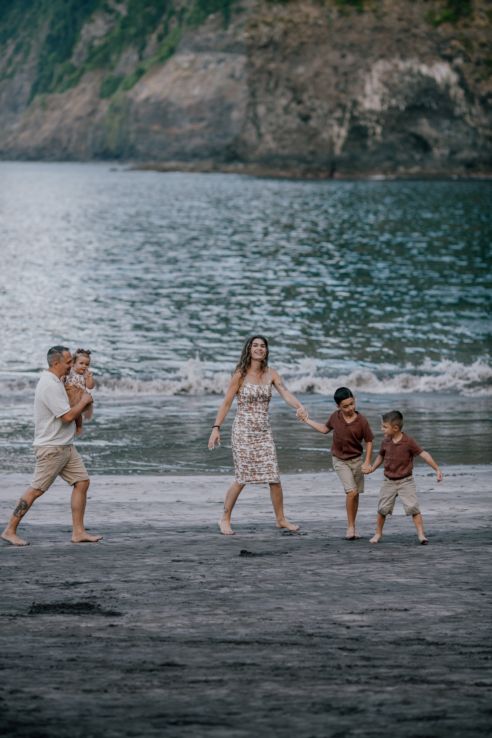 The family walking the tide line at dusk, Seixal Beach, Madeira