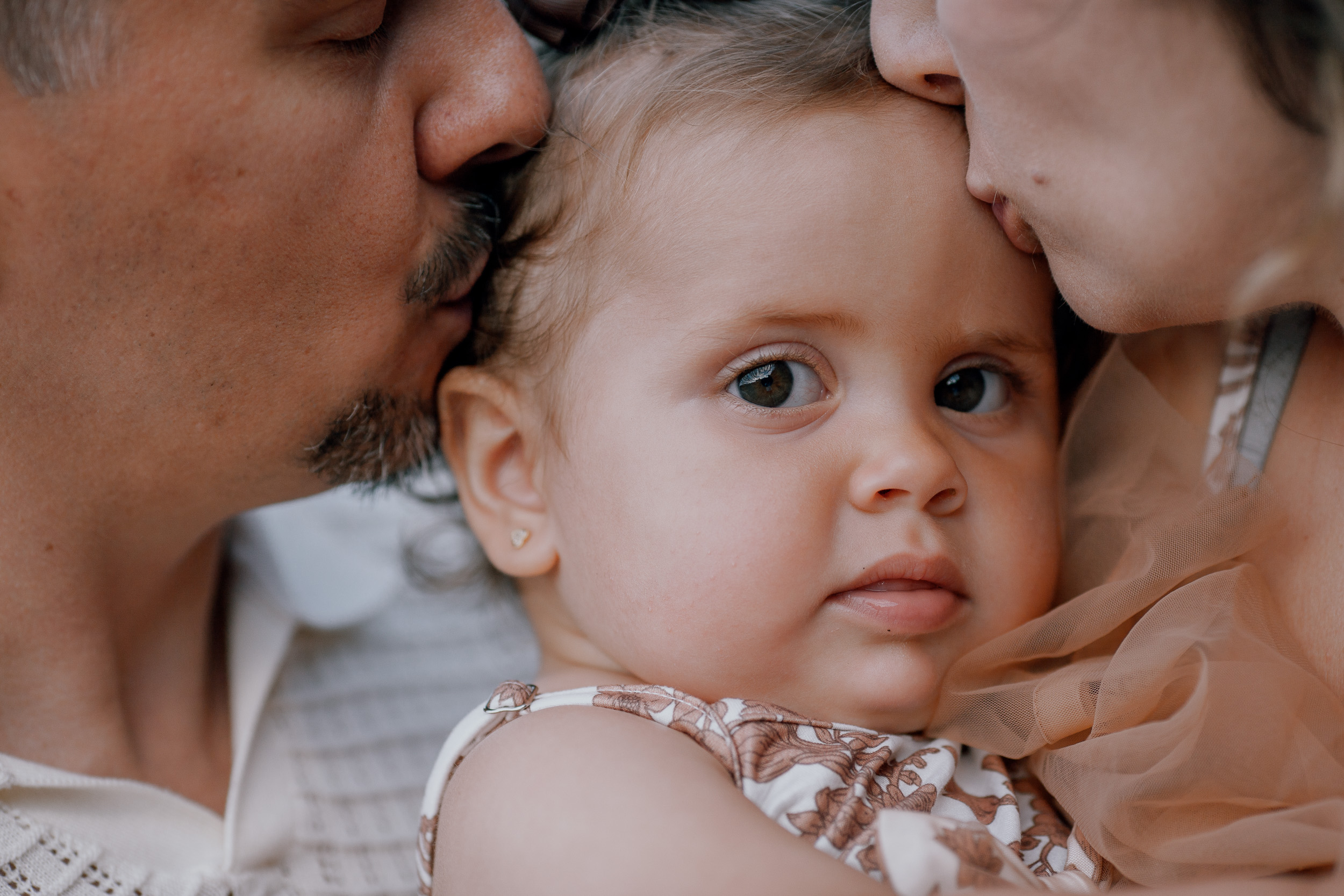 Parents with the baby girl between them at the water, Seixal, Madeira
