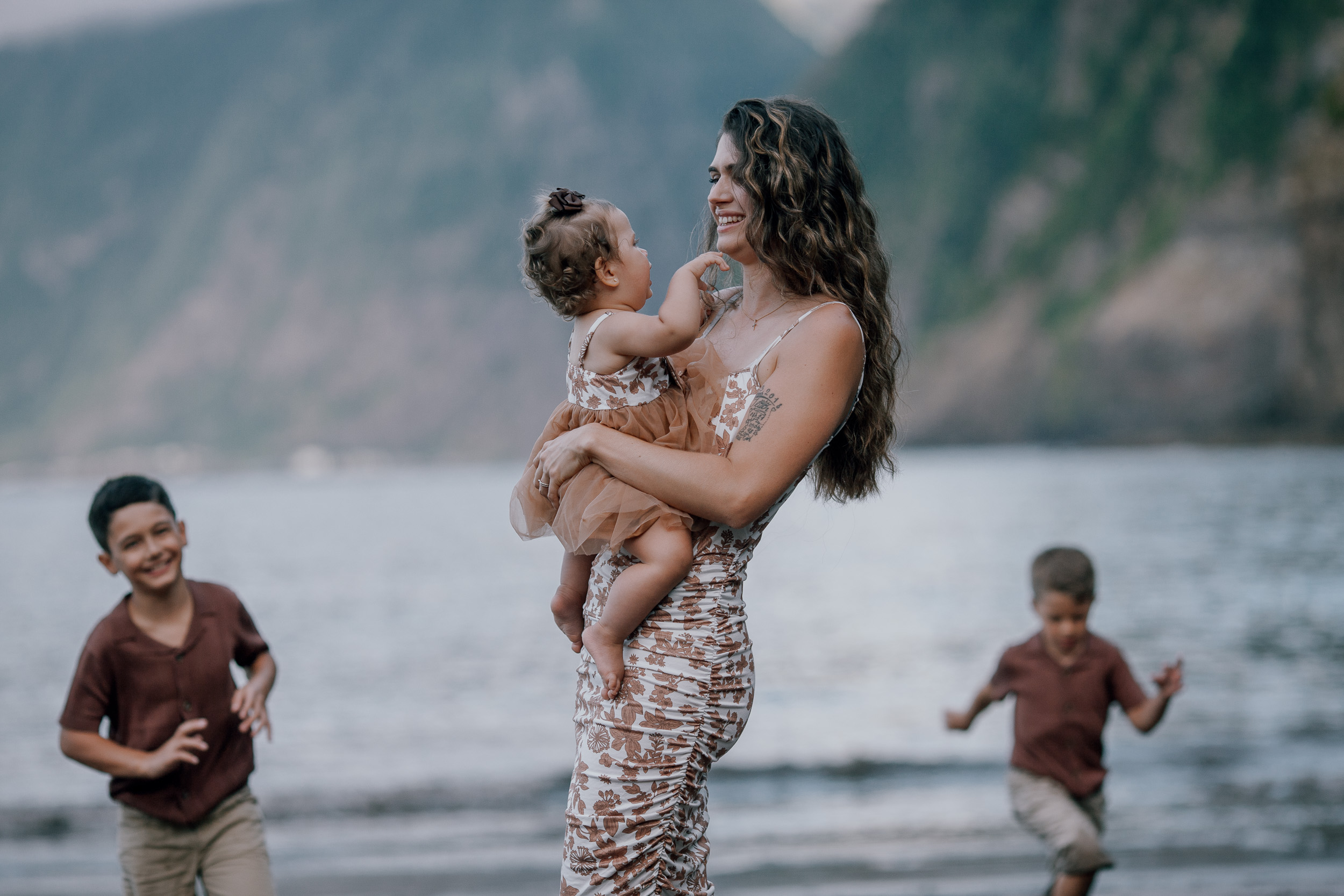 Mum and dad embracing with the baby at dusk, Seixal Beach, Madeira