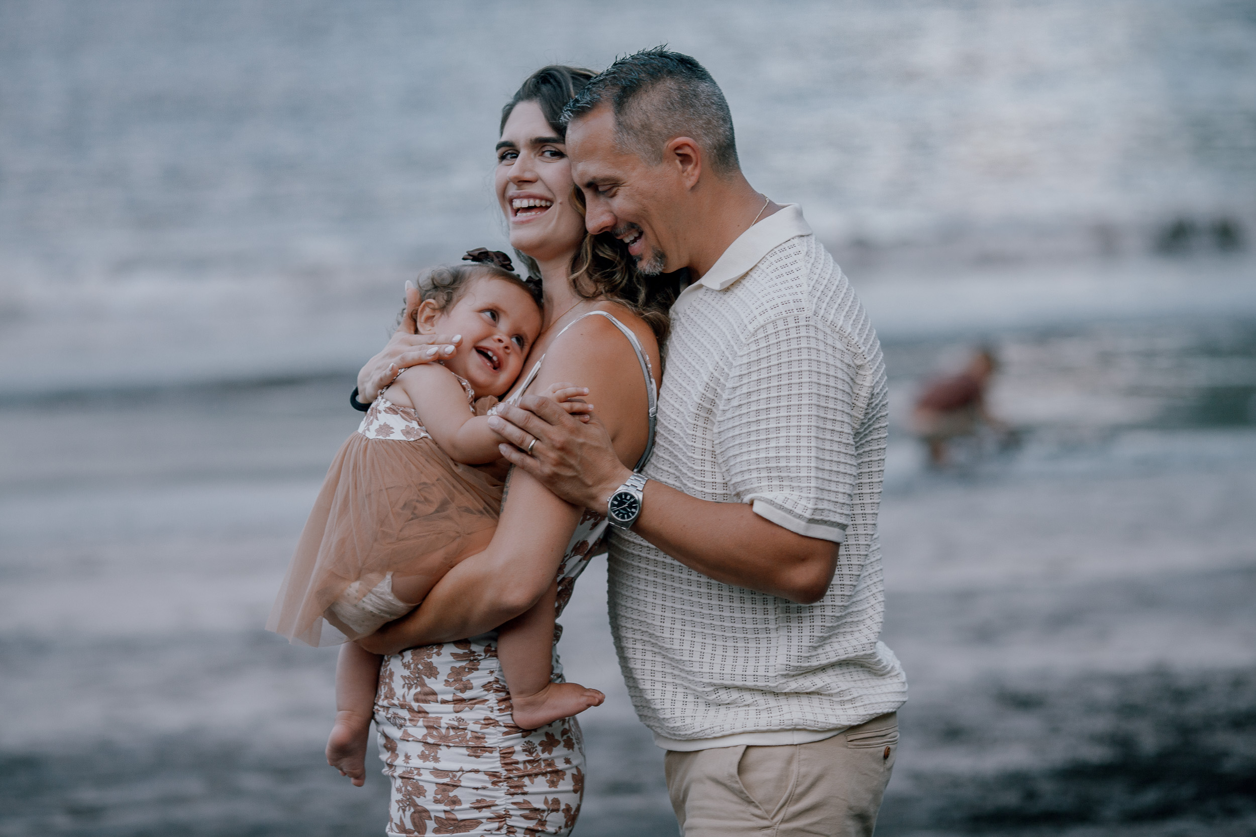 A kiss between the parents holding the baby, Seixal Beach, Madeira