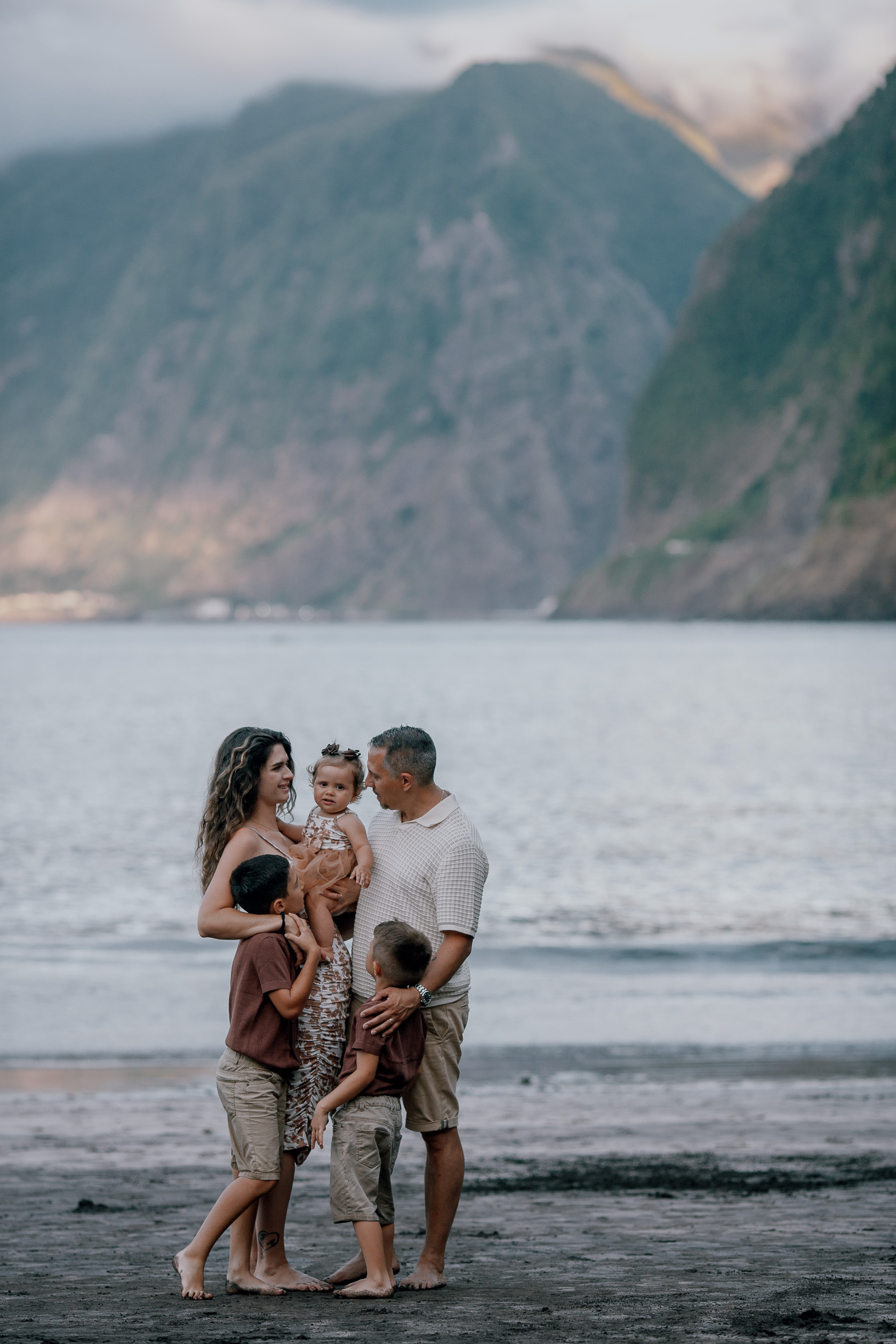The whole family together at the water's edge, cliffs behind, Seixal Beach, Madeira