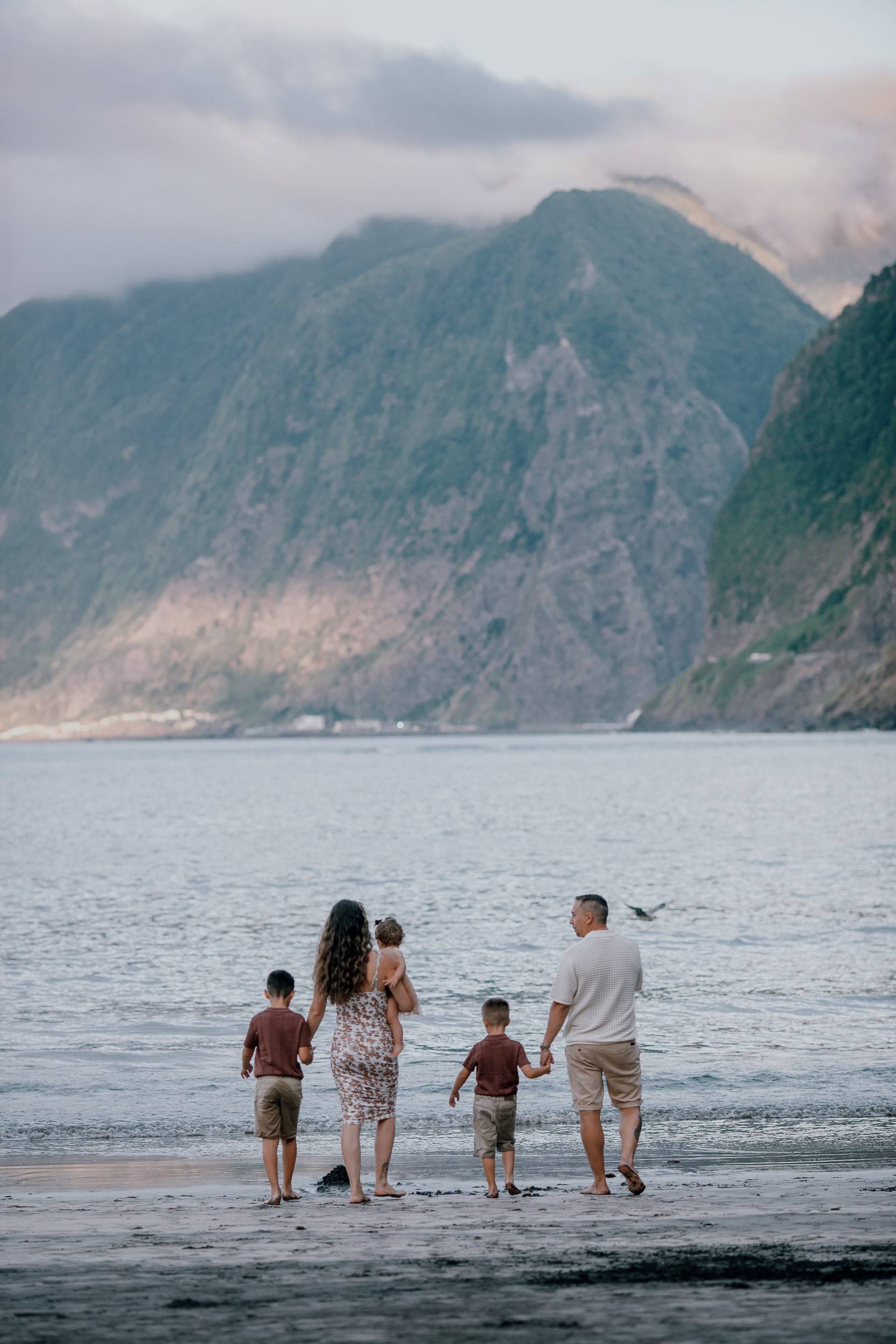 The family far down the beach against the mountains, Seixal, Madeira