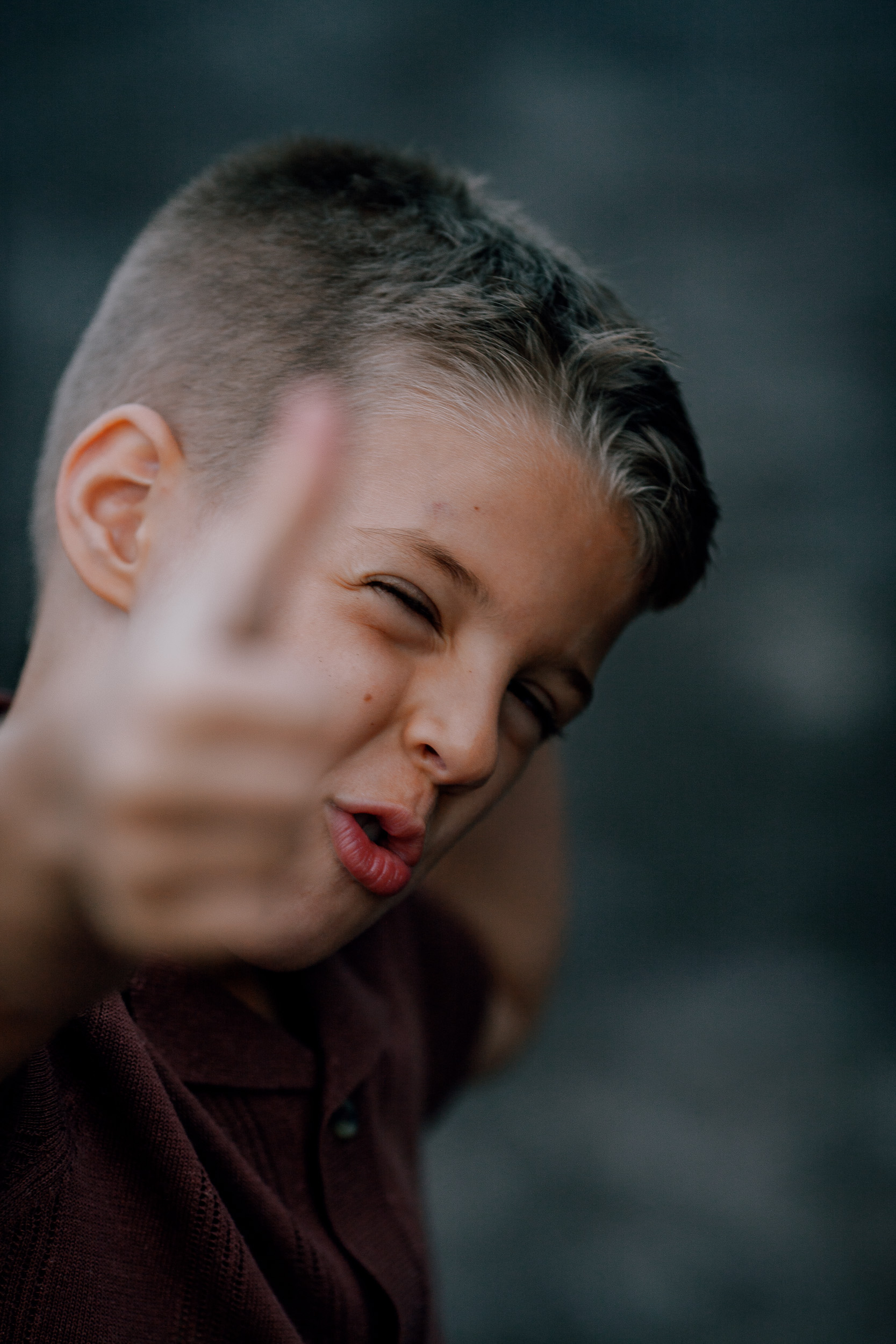 The younger boy pulling a face with a thumbs up, Seixal Beach, Madeira