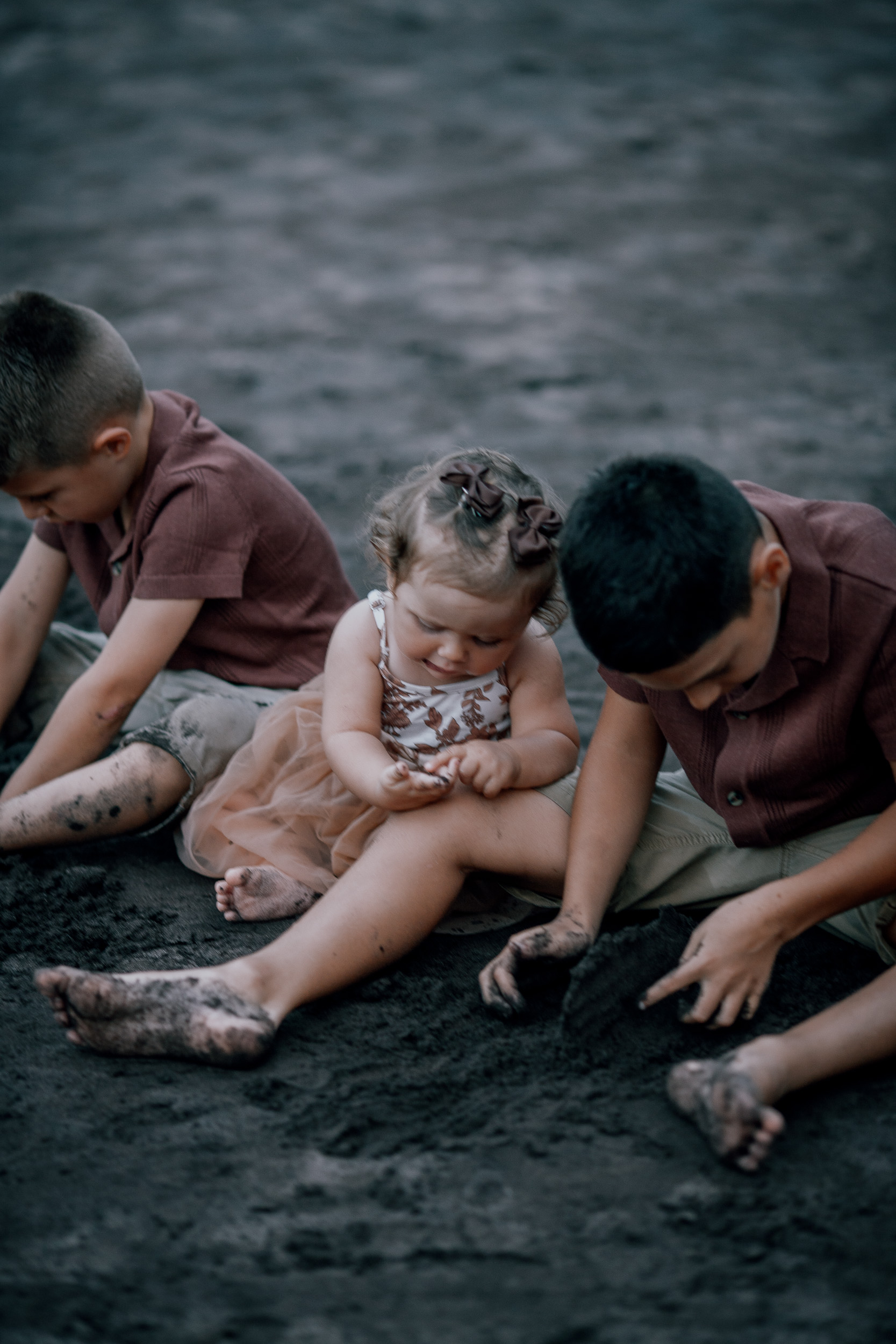 The boys helping their baby sister play in the sand, Seixal Beach, Madeira