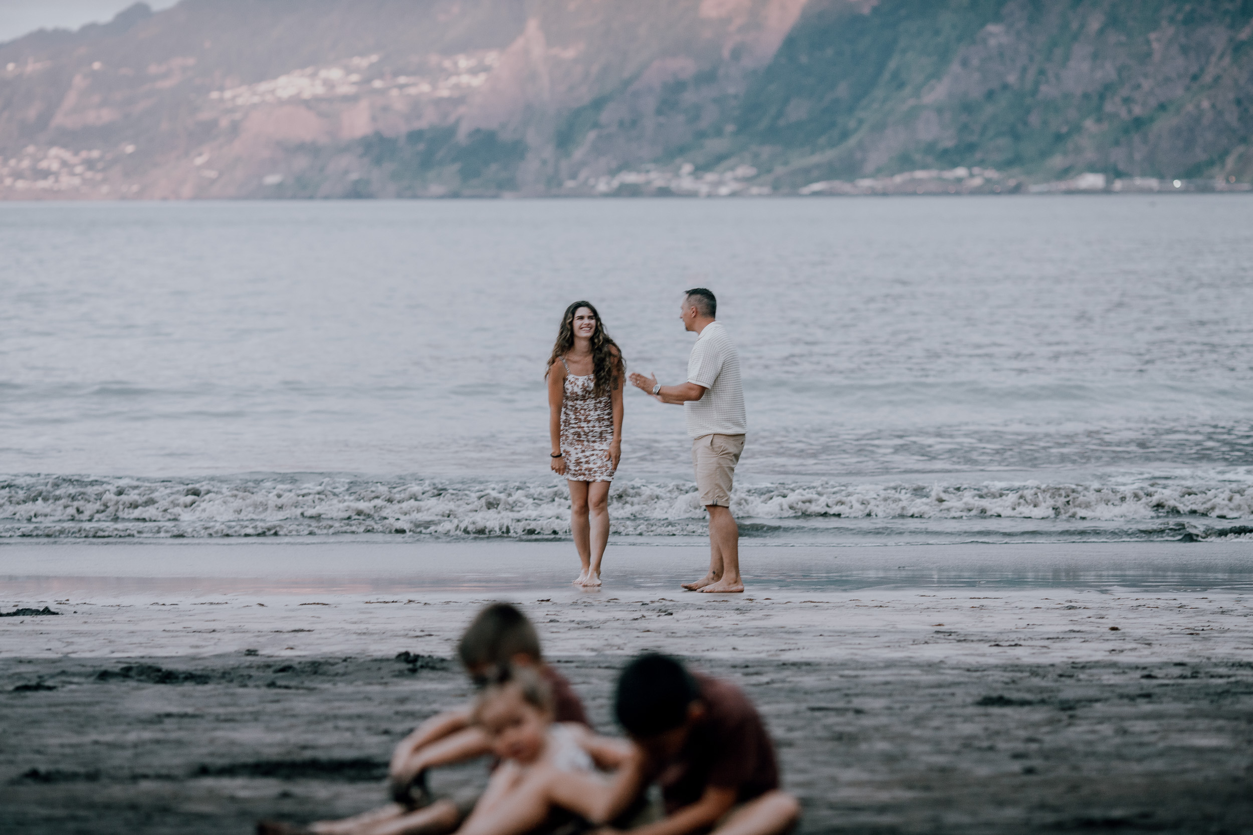 Mum and dad hand in hand at the surf, kids on the sand, Seixal Beach, Madeira